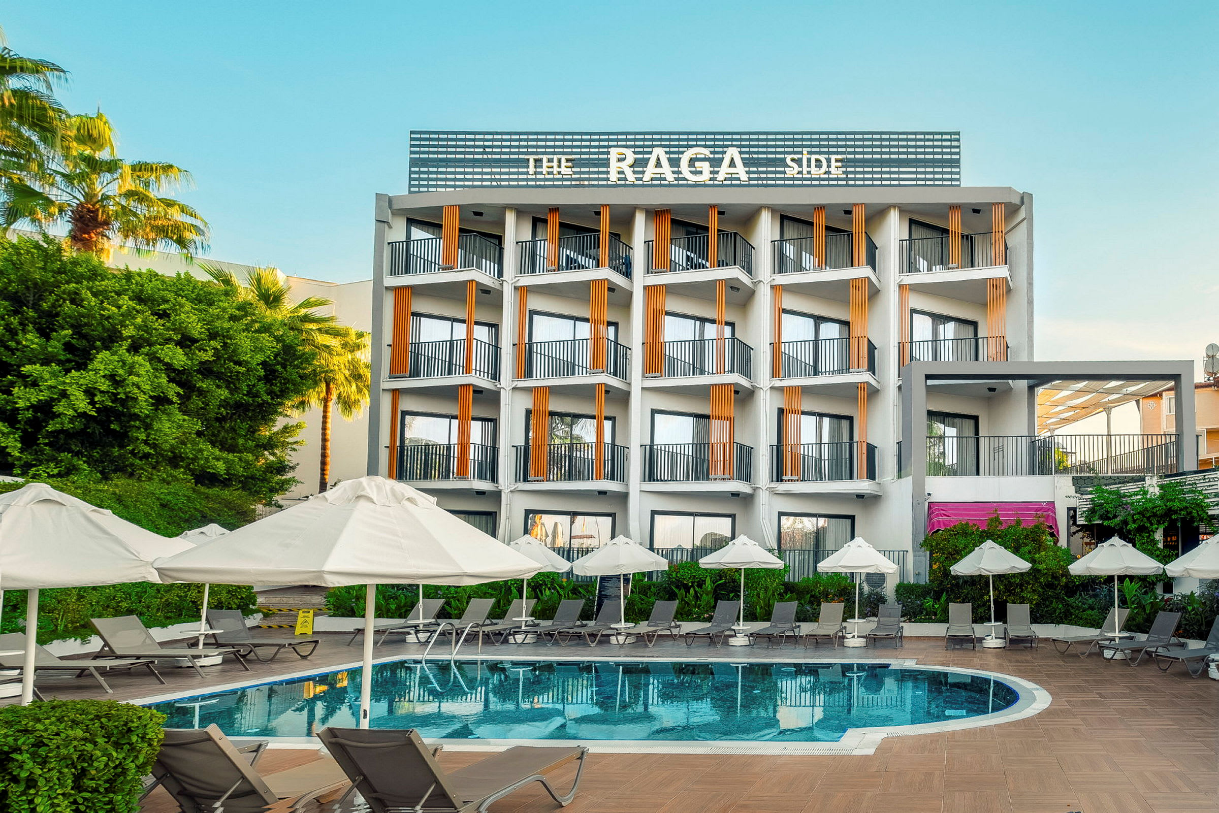 Et hotel med en udendørs pool og liggestole med parasoller. (AI-genereret tekst)