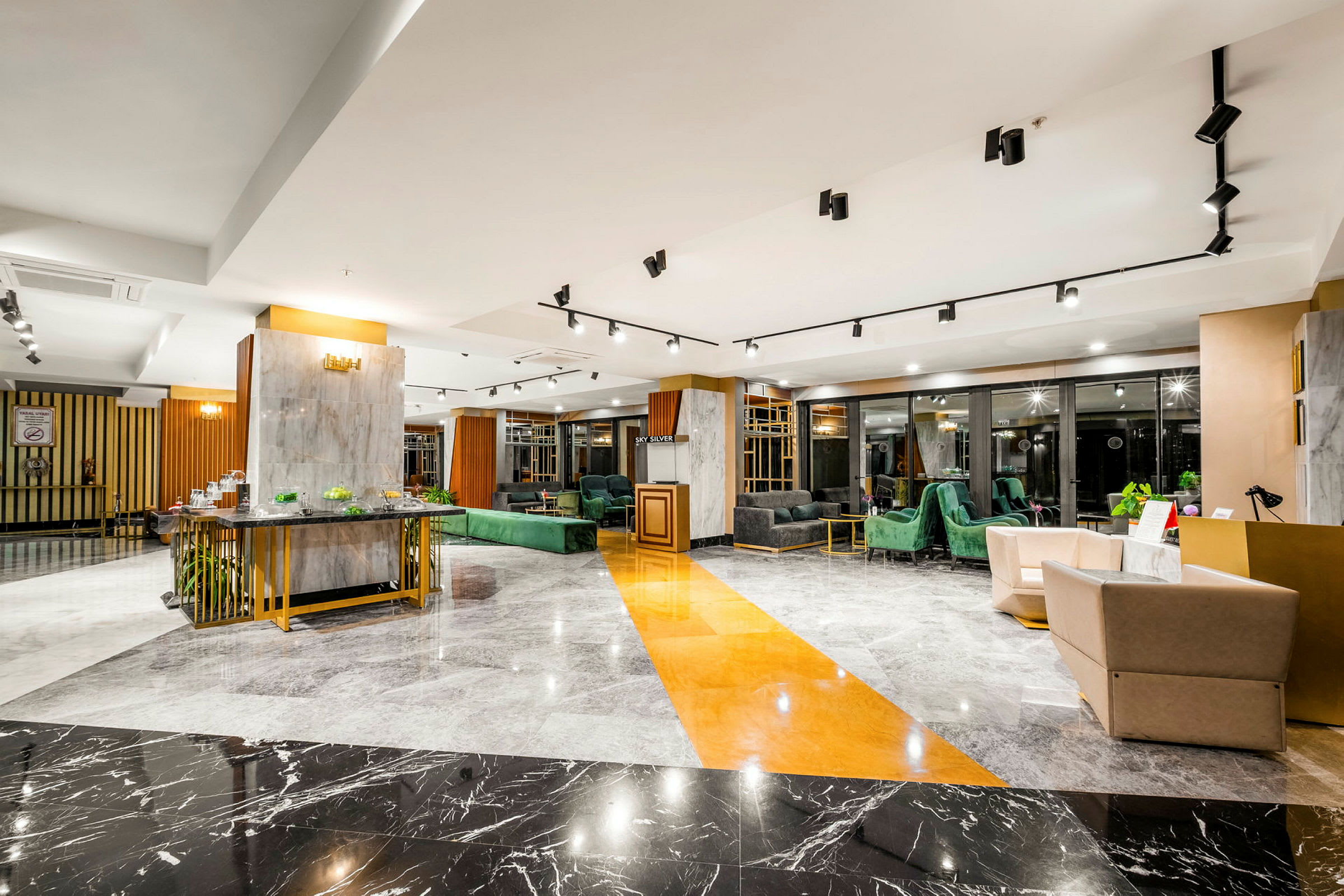 En elegant hotellobby med moderne indretning, marmorgulv og komfortable siddeområder. (AI-genereret tekst)