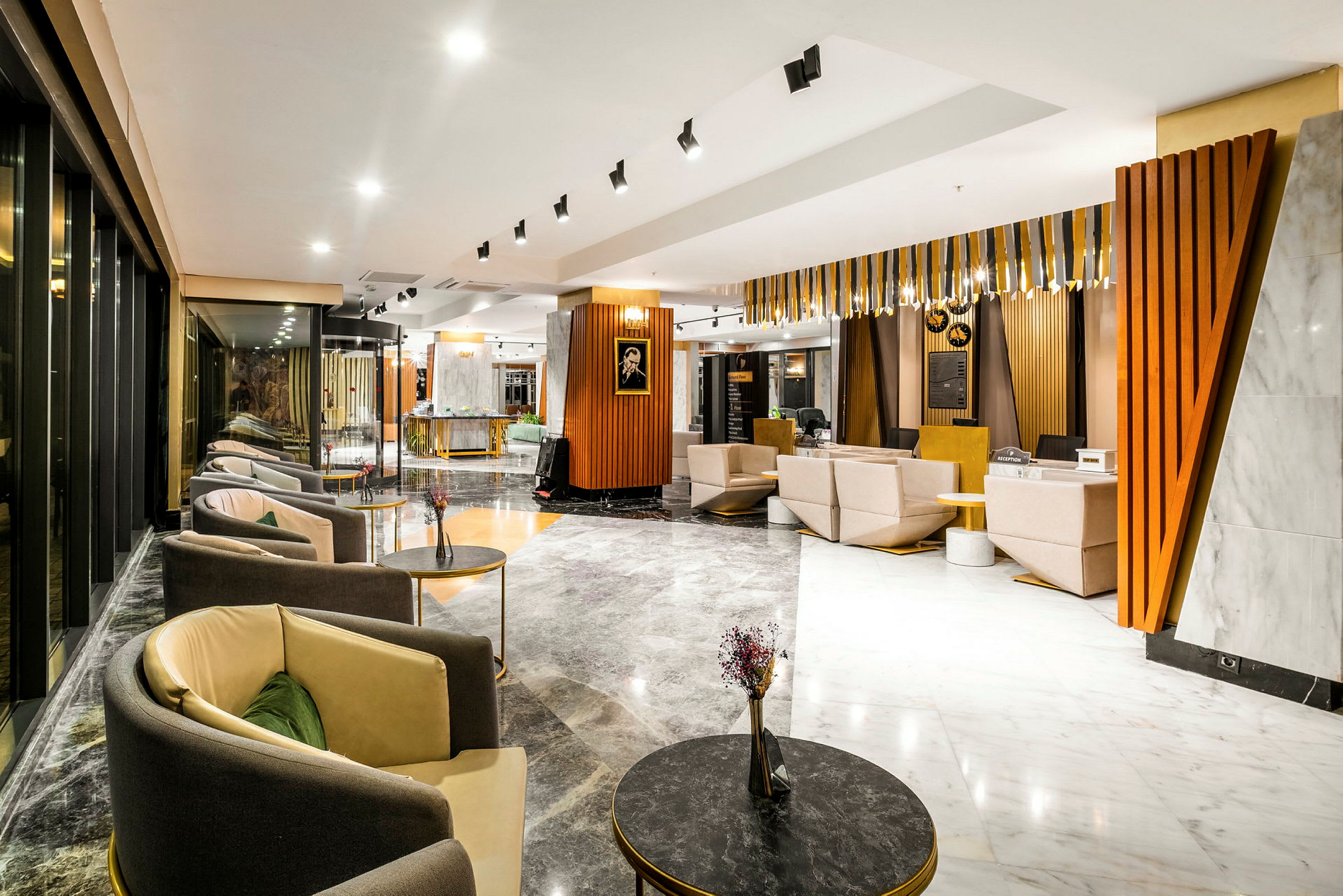 Et moderne hotellobbyområde med siddegrupper, sofaer og borde i et stilfuldt miljø med lyse farver og træmaterialer. (AI-genereret tekst)