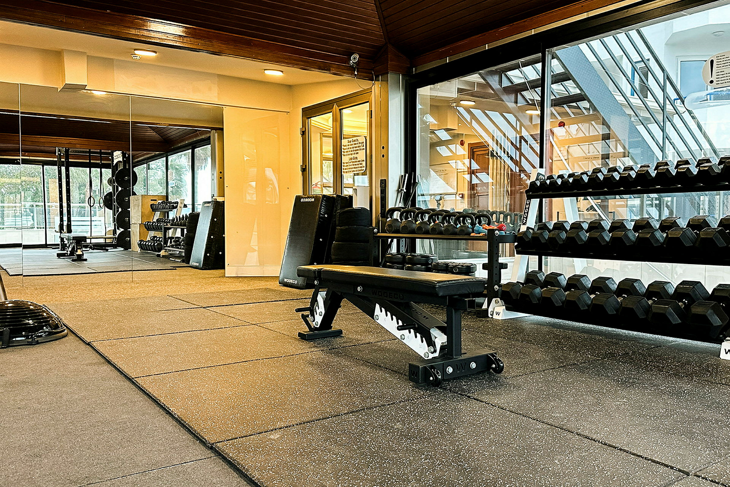 Indretning af et fitnesscenter med træningsudstyr, vægte og en træningsbænk. (AI-genereret tekst)