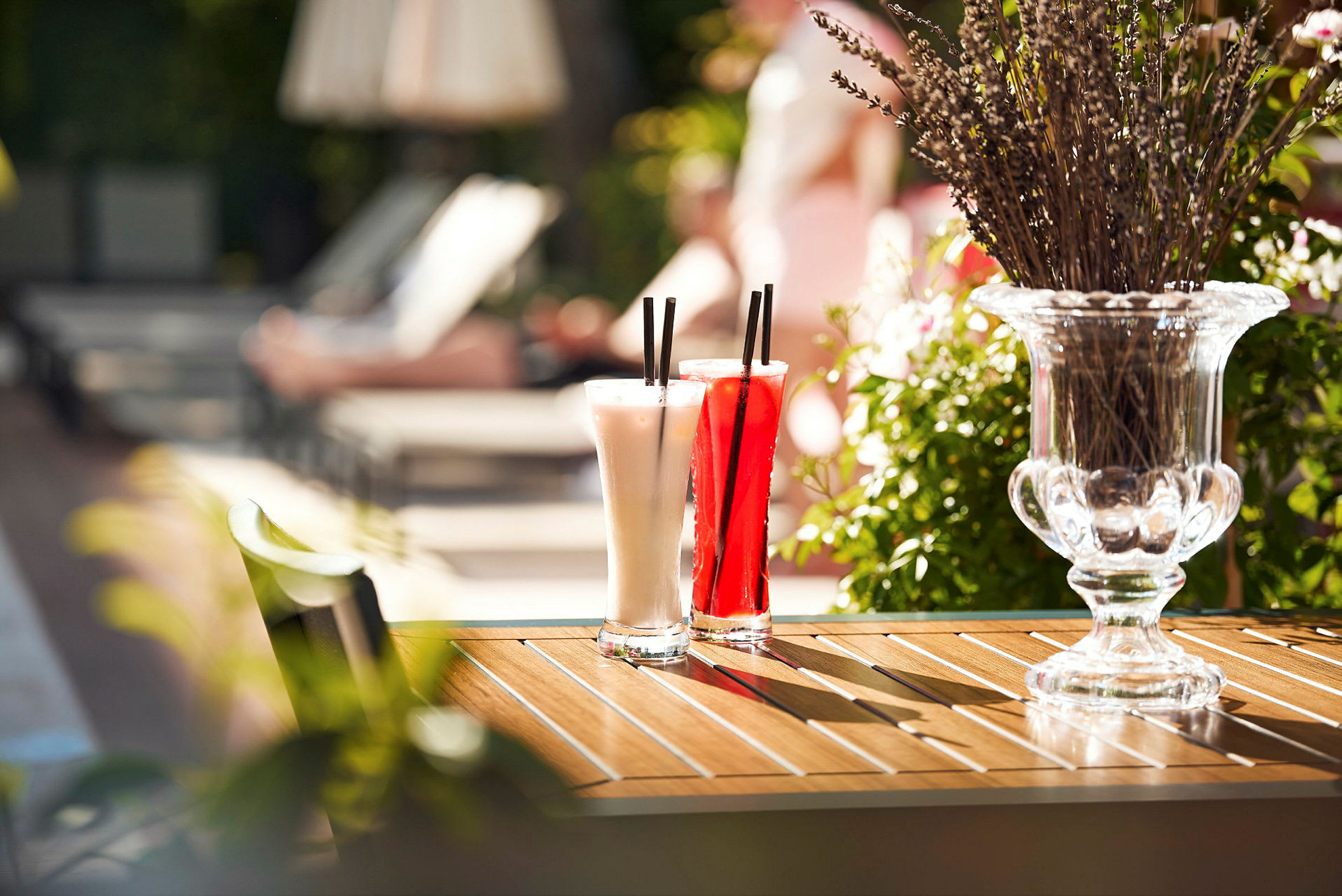 To cocktailglas står på et bord ved siden af en vase med lavendel. (AI-genereret tekst)