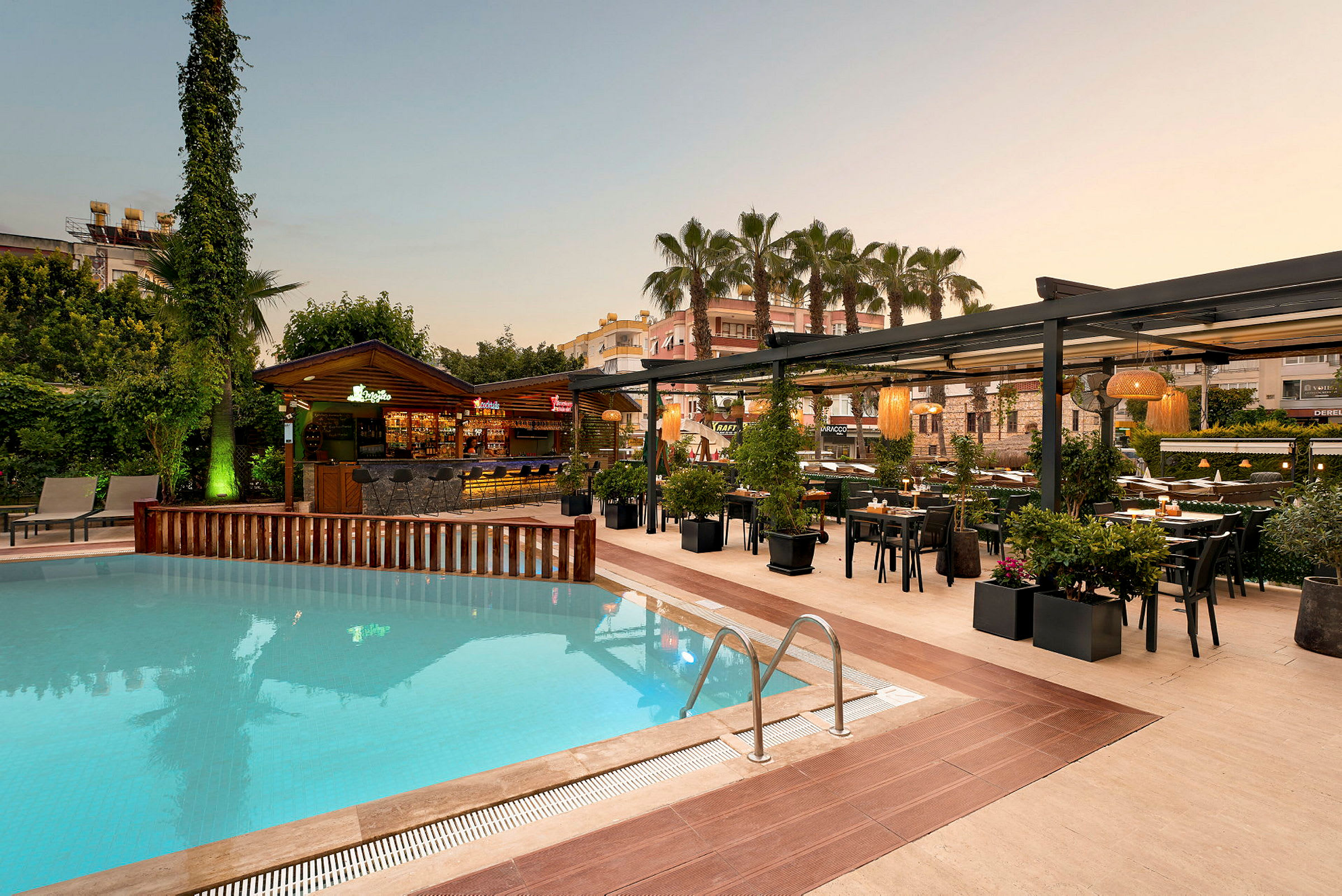 Poolområde med liggestole, en bar og en restaurant med spiseborde under pergola. (AI-genereret tekst)