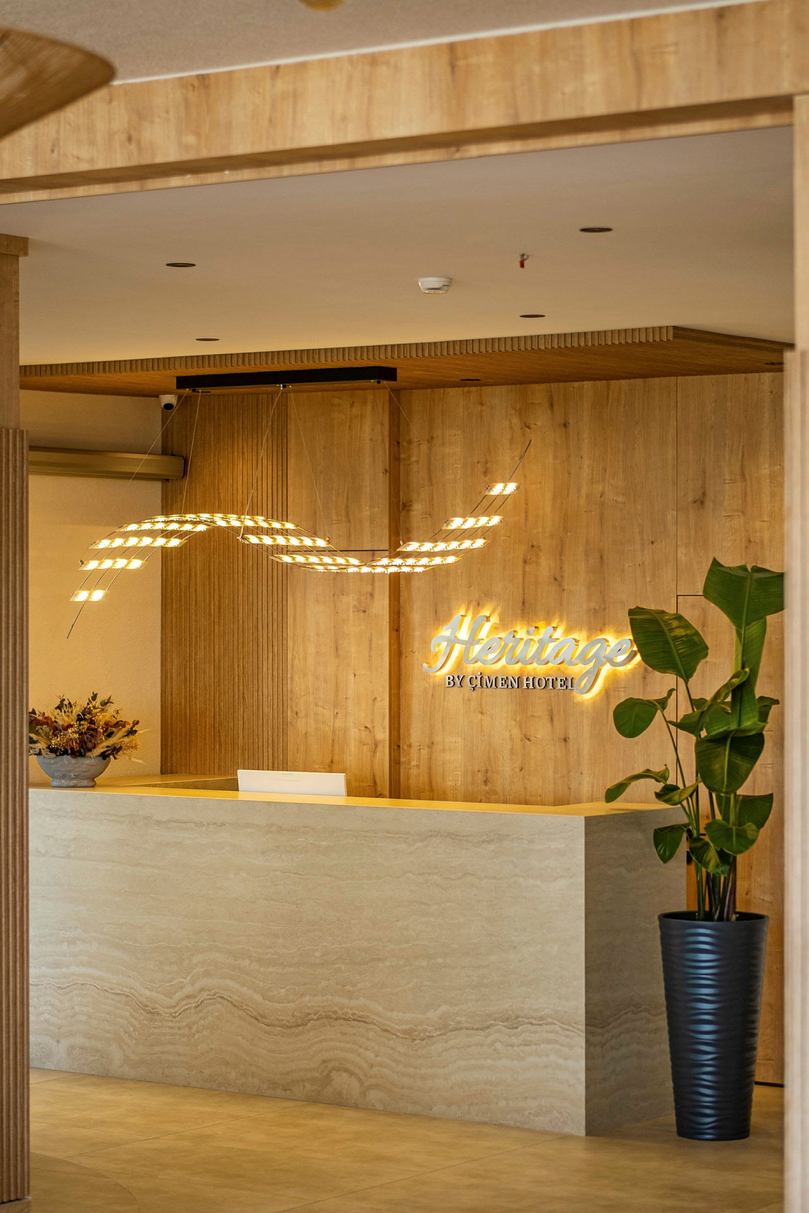 Hotellets lobby med receptionsdisk, væg med træpanel og dekorationer. (AI-genereret tekst)