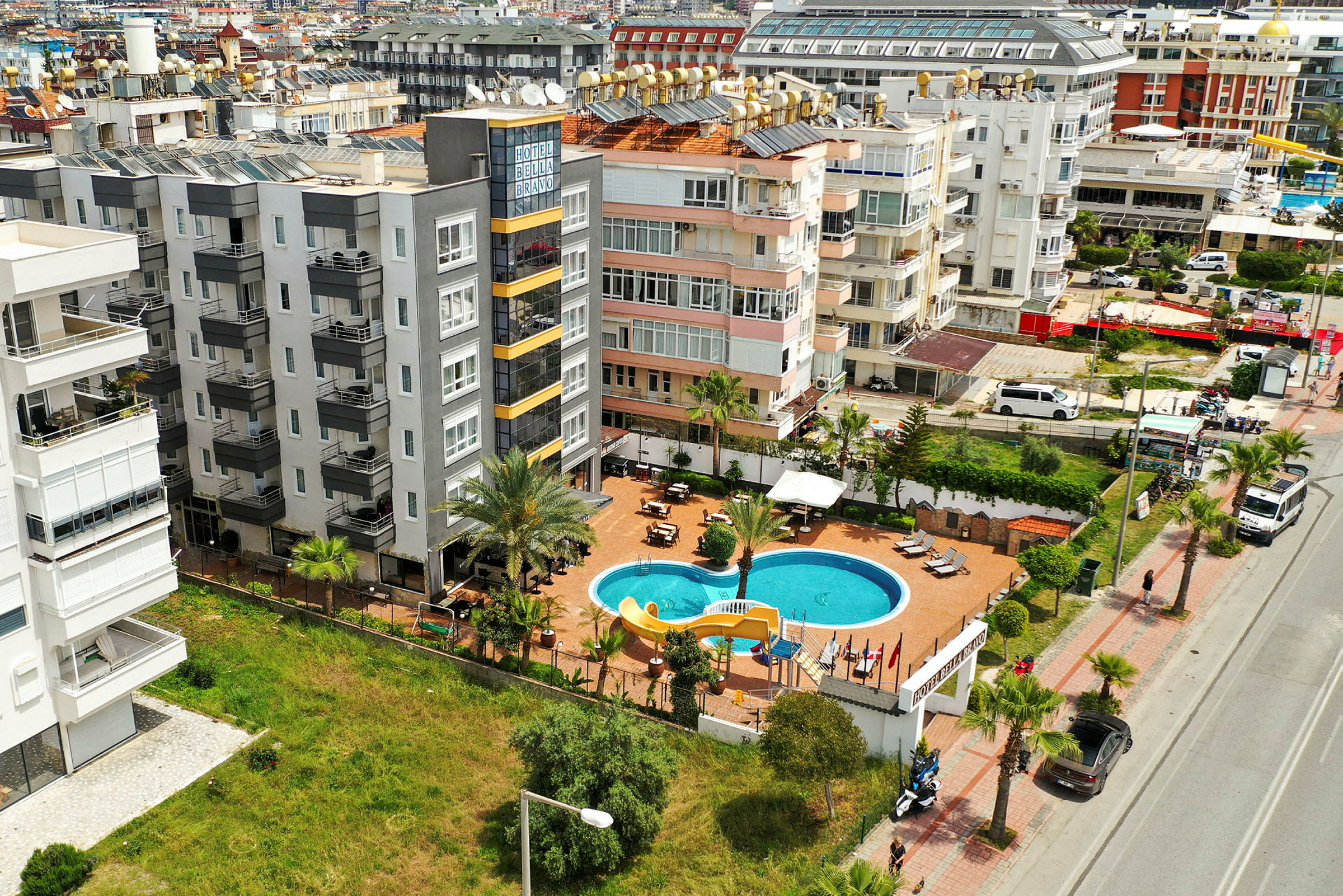 Et luftfoto viser et hotelområde med en swimmingpool og omkringliggende bygninger. (AI-genereret tekst)