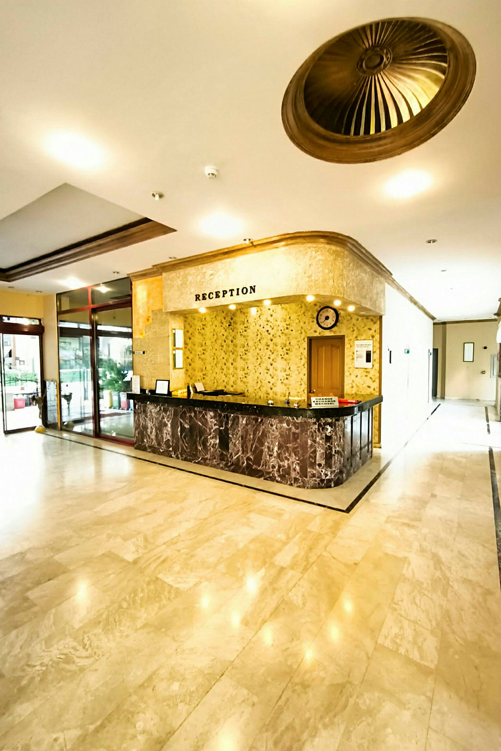 Hotellets reception med marmordetaljer og lyse vægge. (AI-genereret tekst)