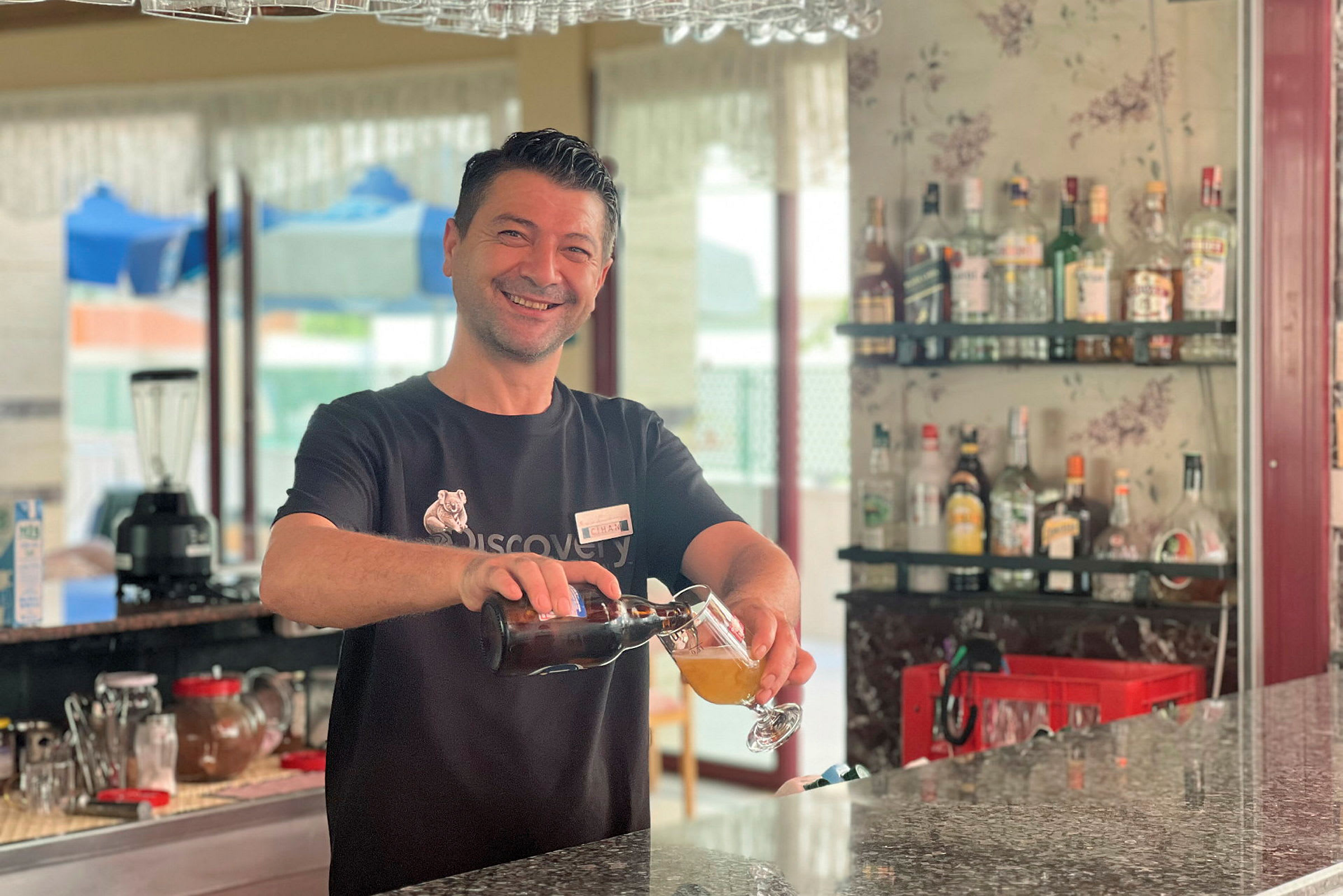 En bartender hælder en drink op ved en bar. (AI-genereret tekst)