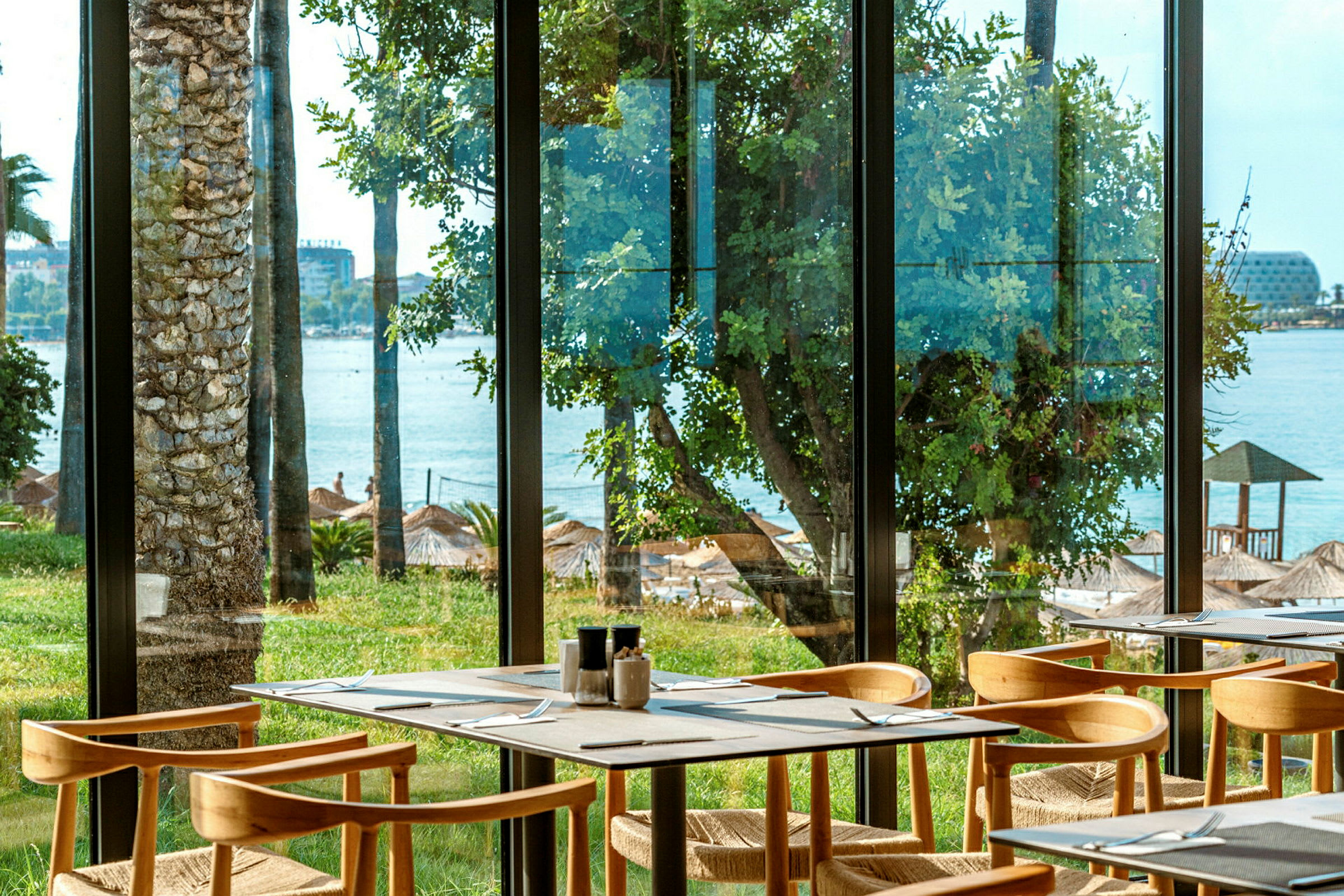 Restaurant med udsigt over stranden gennem vinduer. (AI-genereret tekst)