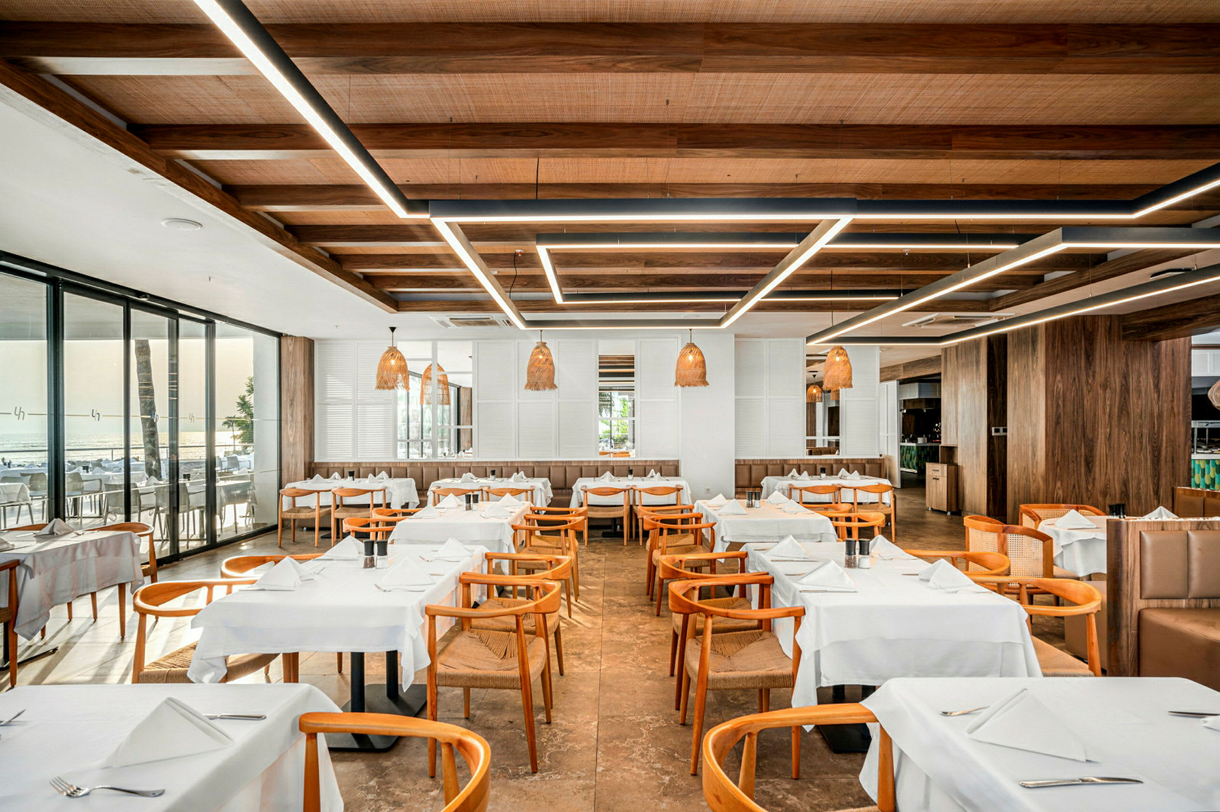 En restaurant med træstole og hviddugede borde. (AI-genereret tekst)