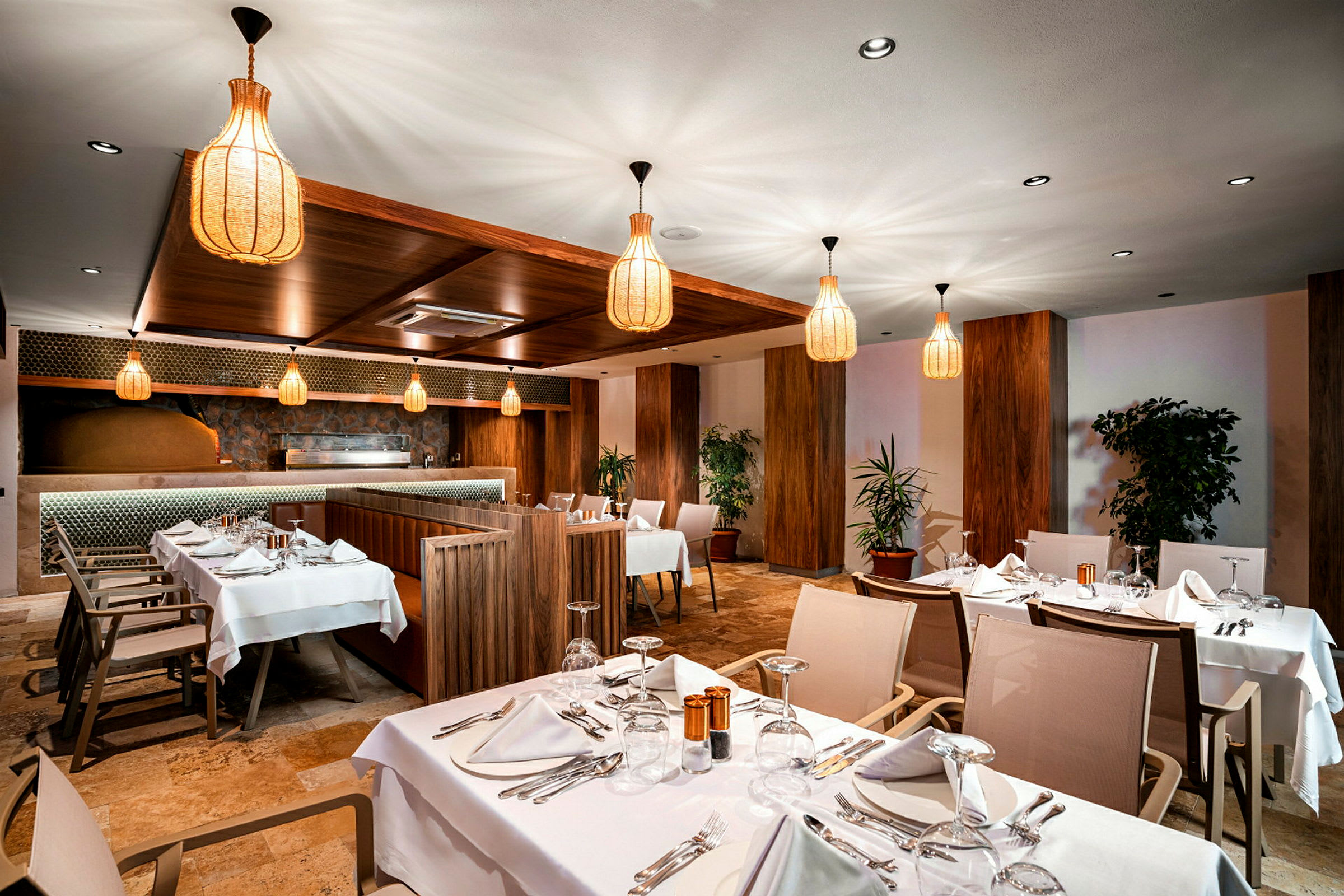 Interiør af en restaurant med opdækkede borde og elegant belysning. (AI-genereret tekst)