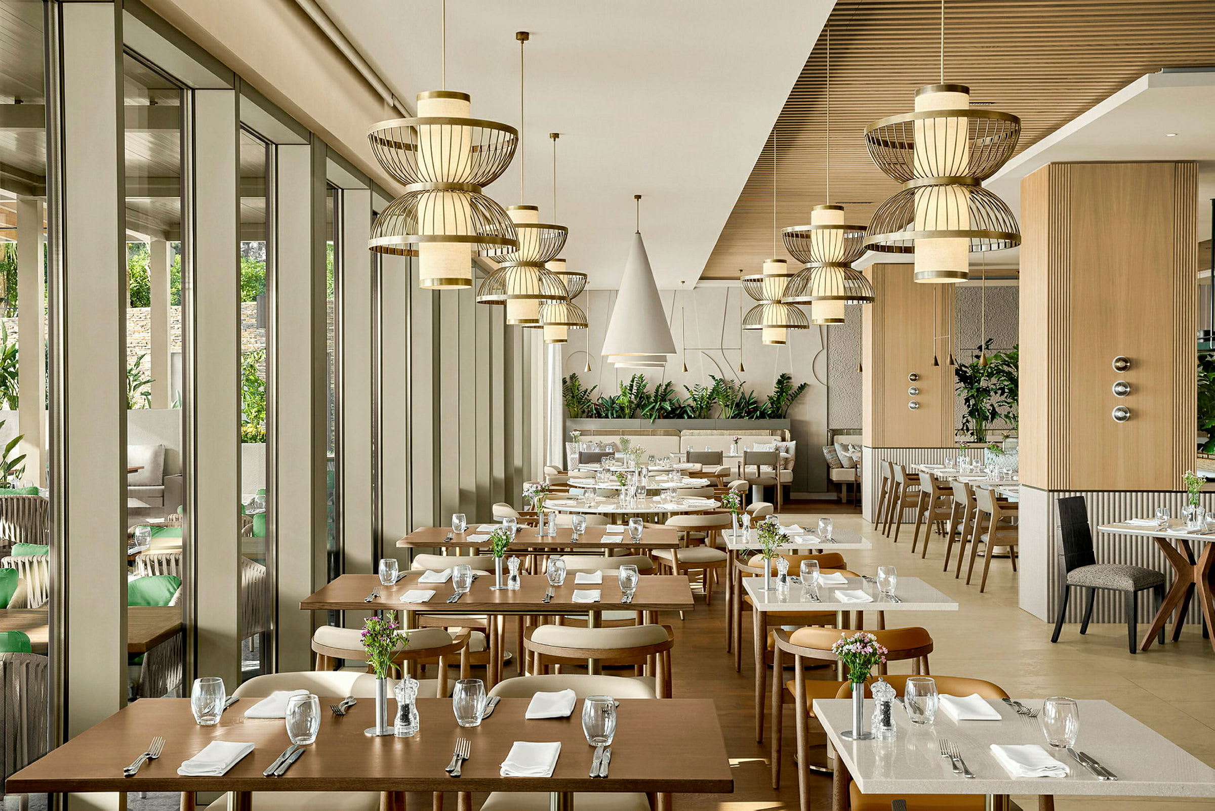 En moderne restaurant med elegante borde og stole samt dekorative loftslamper. (AI-genereret tekst)