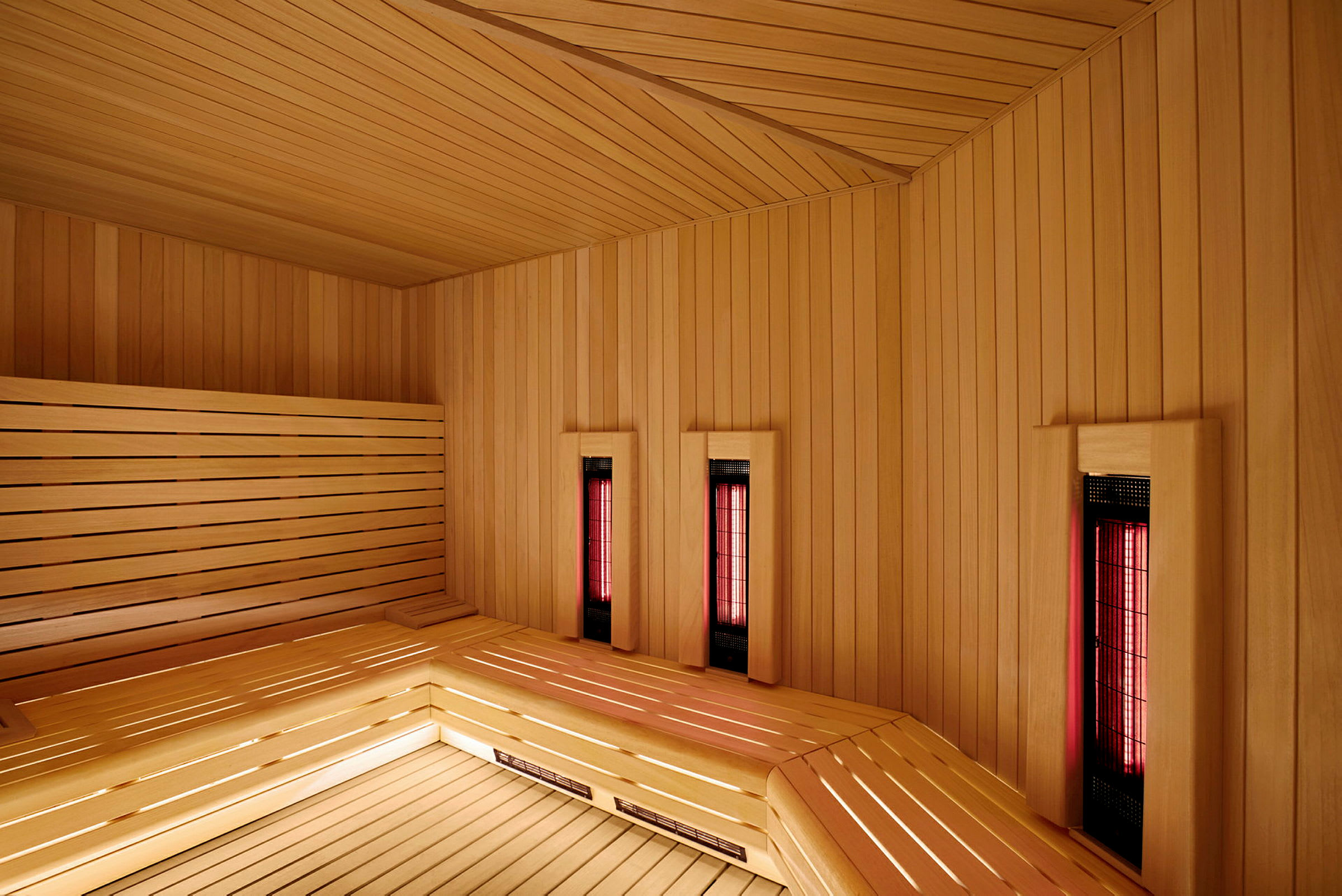 Inde i en sauna med træinteriør og infrarød varme. (AI-genereret tekst)