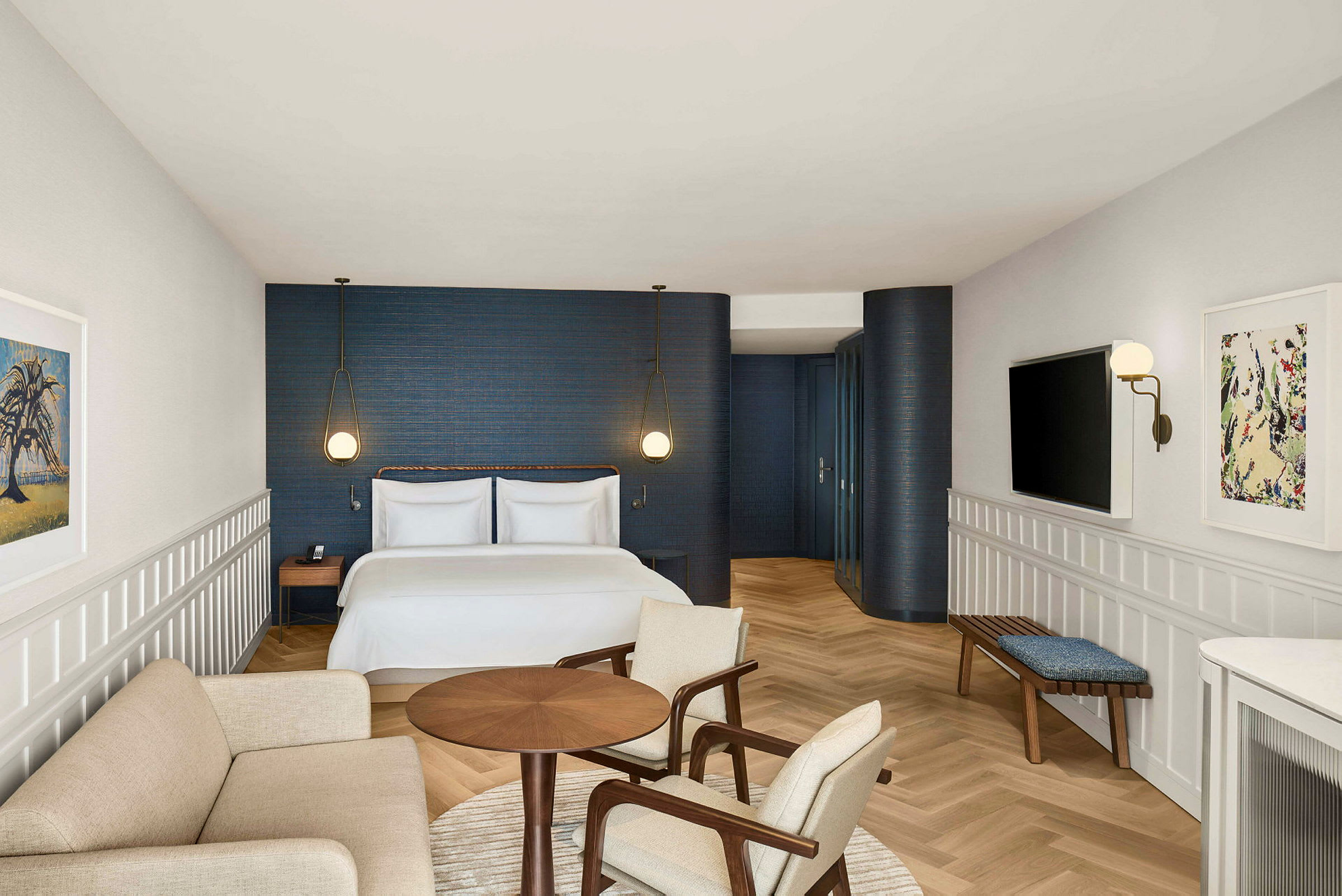 Et hotelværelse med en dobbeltseng, en siddegruppe og et moderne design med blå vægge og lyse trædetaljer. (AI-genereret tekst)