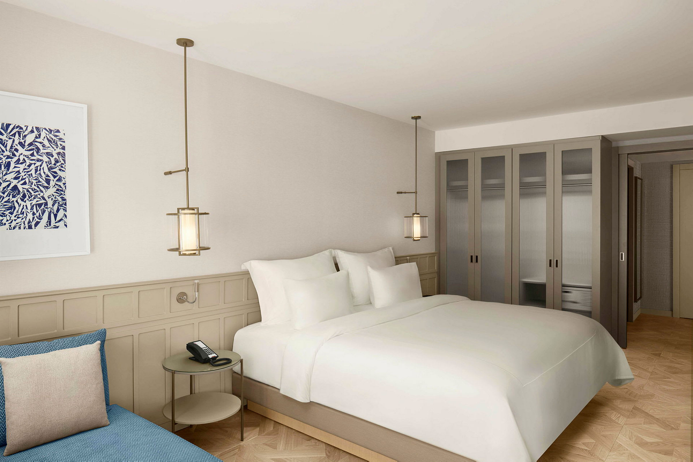 Et moderne hotelværelse med stor seng, et sofabord og garderobeskabe. (AI-genereret tekst)