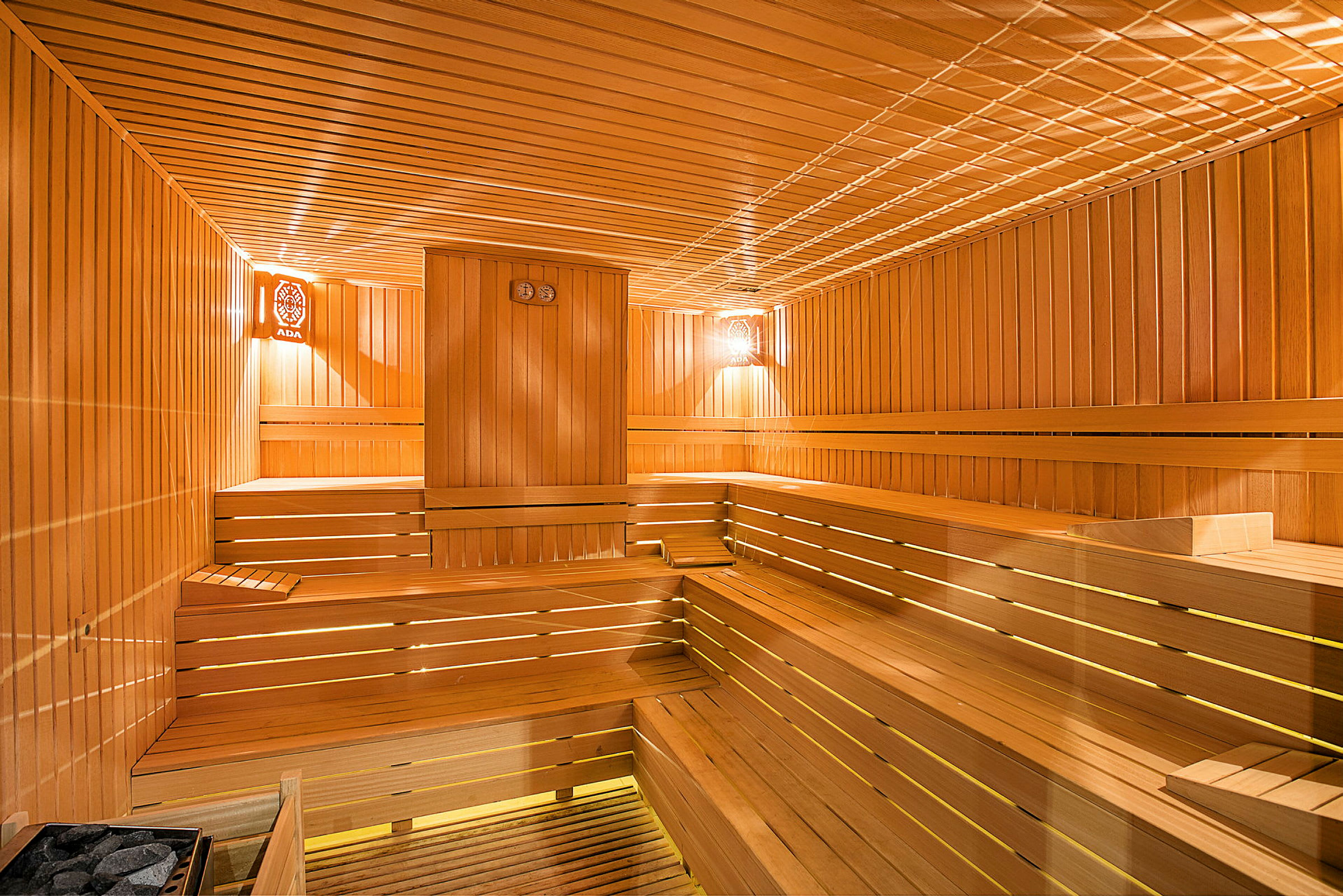Interiøret i en sauna med træpaneler og siddepladser. (AI-genereret tekst)