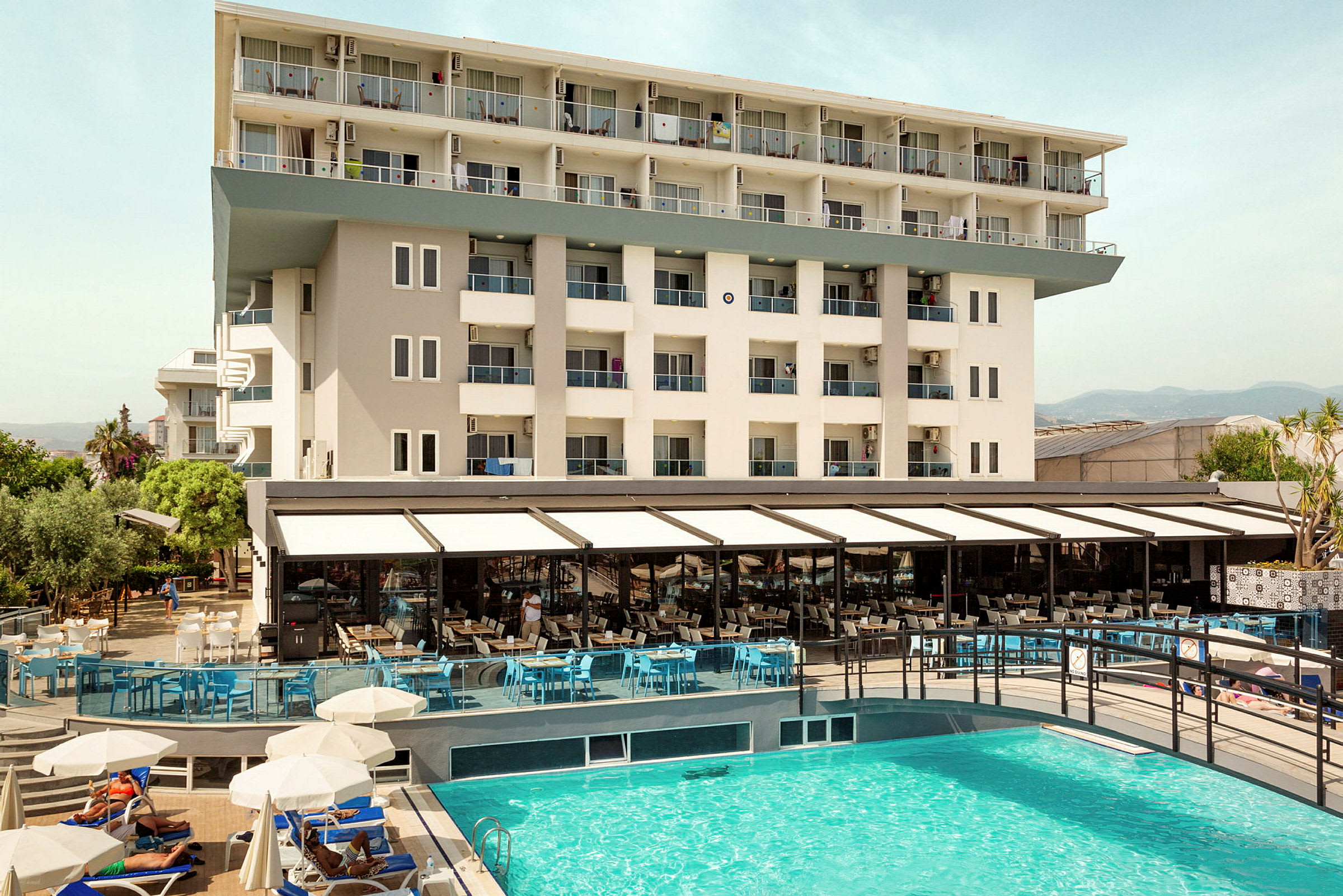 Udsigt over hotelbygning og udendørs pool. (AI-genereret tekst)
