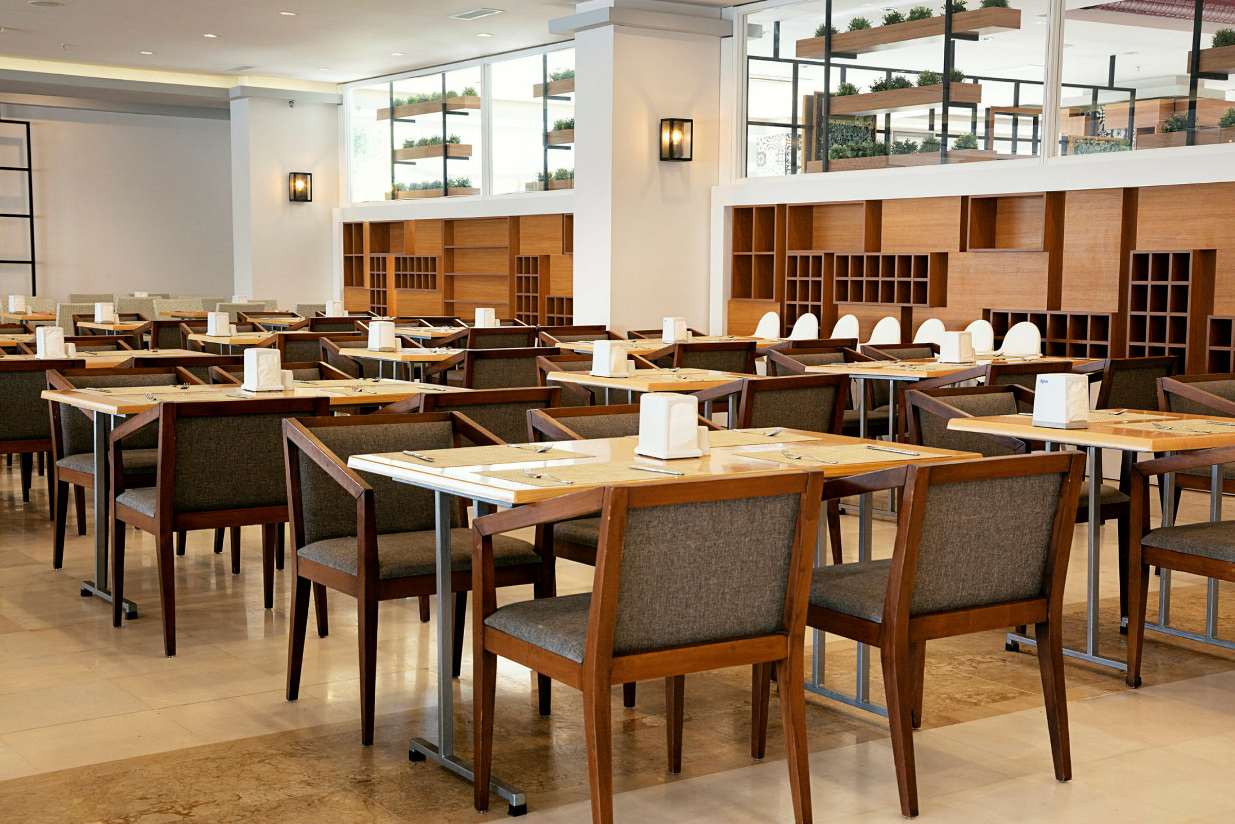 Restaurant med flere borde og træstole, indrettet med hylder og dekorationer. (AI-genereret tekst)