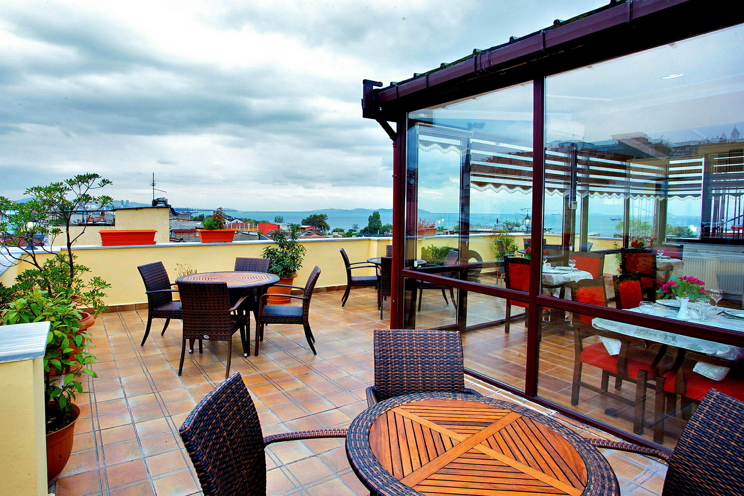 Terrasse med borde og stole, indendørs og udendørs miljø. (AI-genereret tekst)