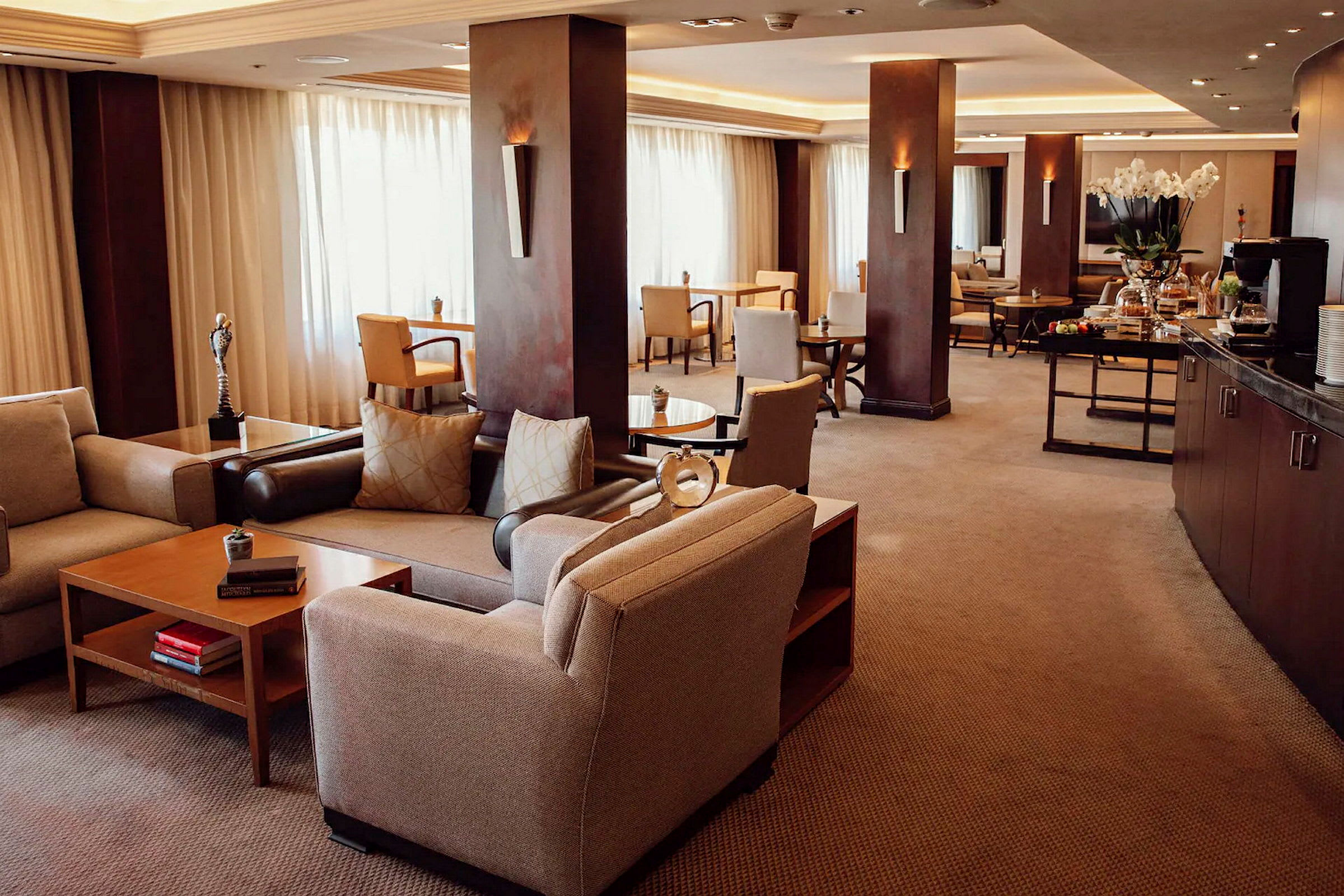 En indbydende hotel-lounge med komfortable siddepladser og borde. (AI-genereret tekst)