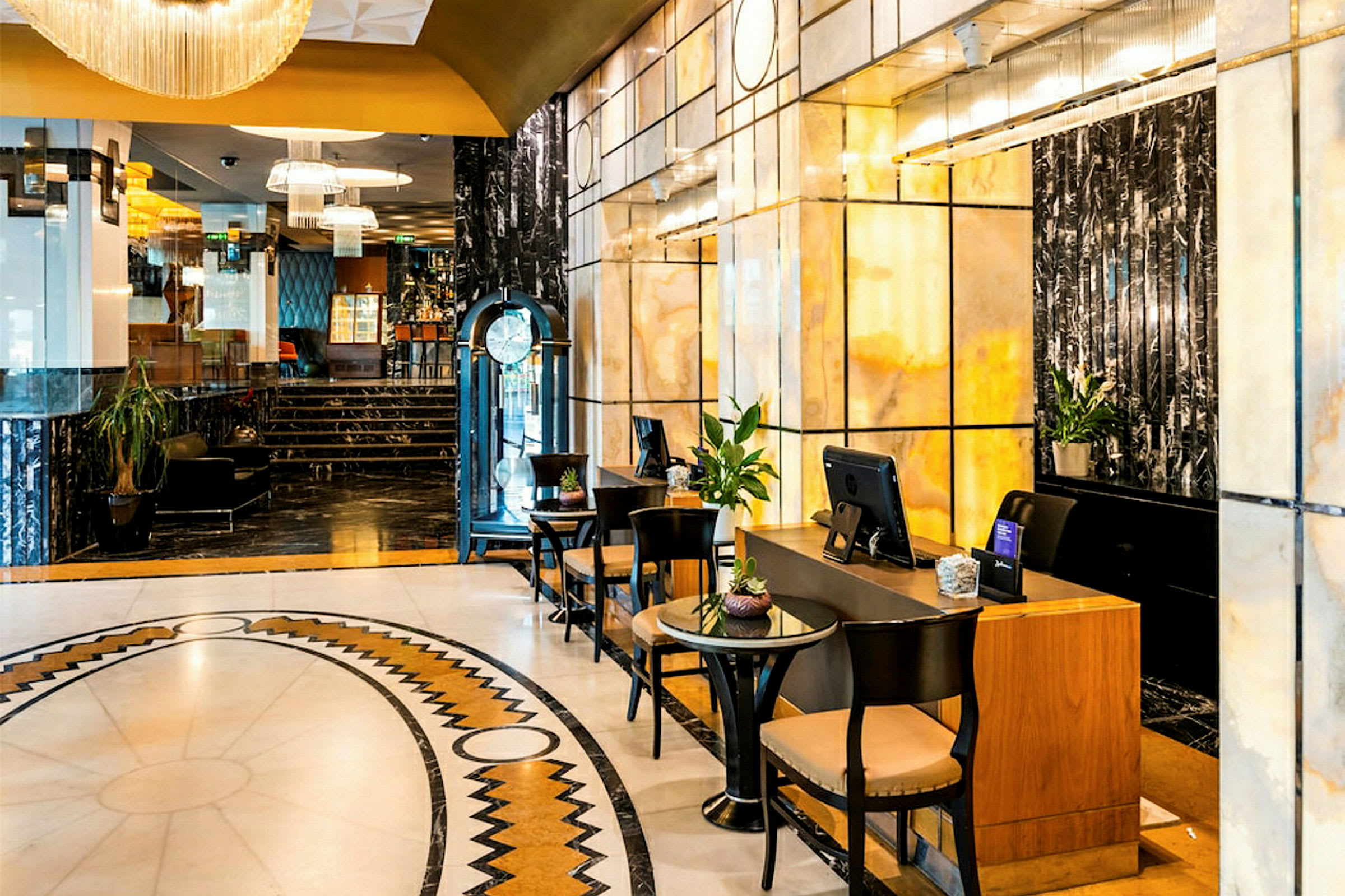 Et elegant hotellobbyområde med marmormure, en reception og siddepladser. (AI-genereret tekst)