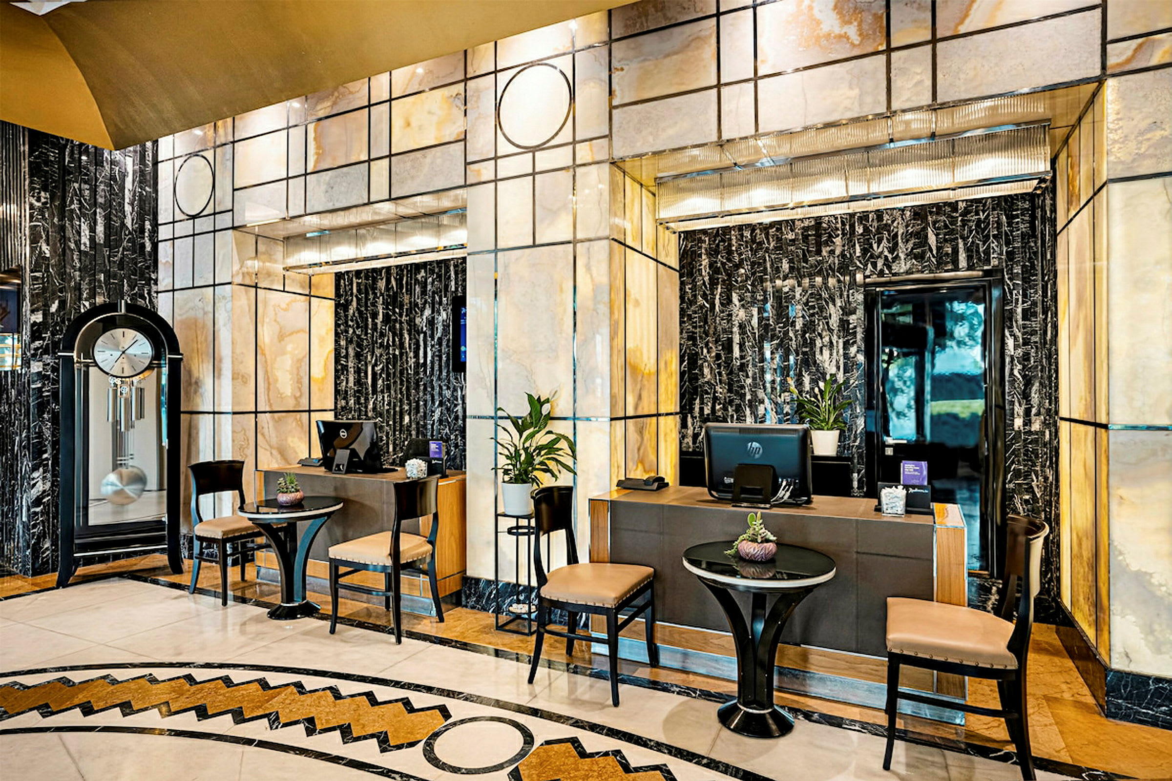 Billede der viser en reception med elegant indretning, forskellige siddepladser, borddekorationer og et ur. (AI-genereret tekst)