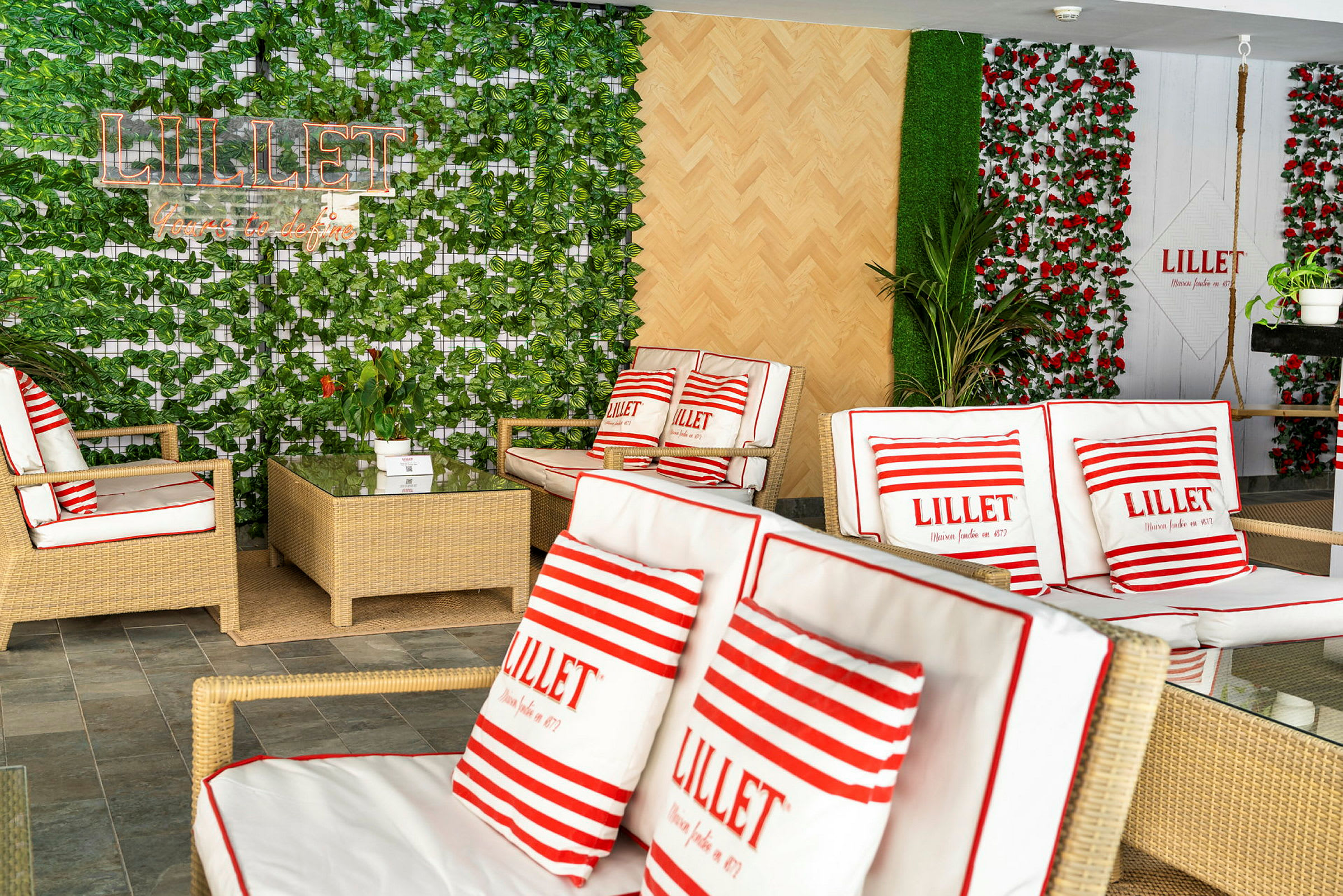 Et rum med rottingmøbler og planter, dekoreret med puder med teksten 'Lillet'. (AI-genereret tekst)