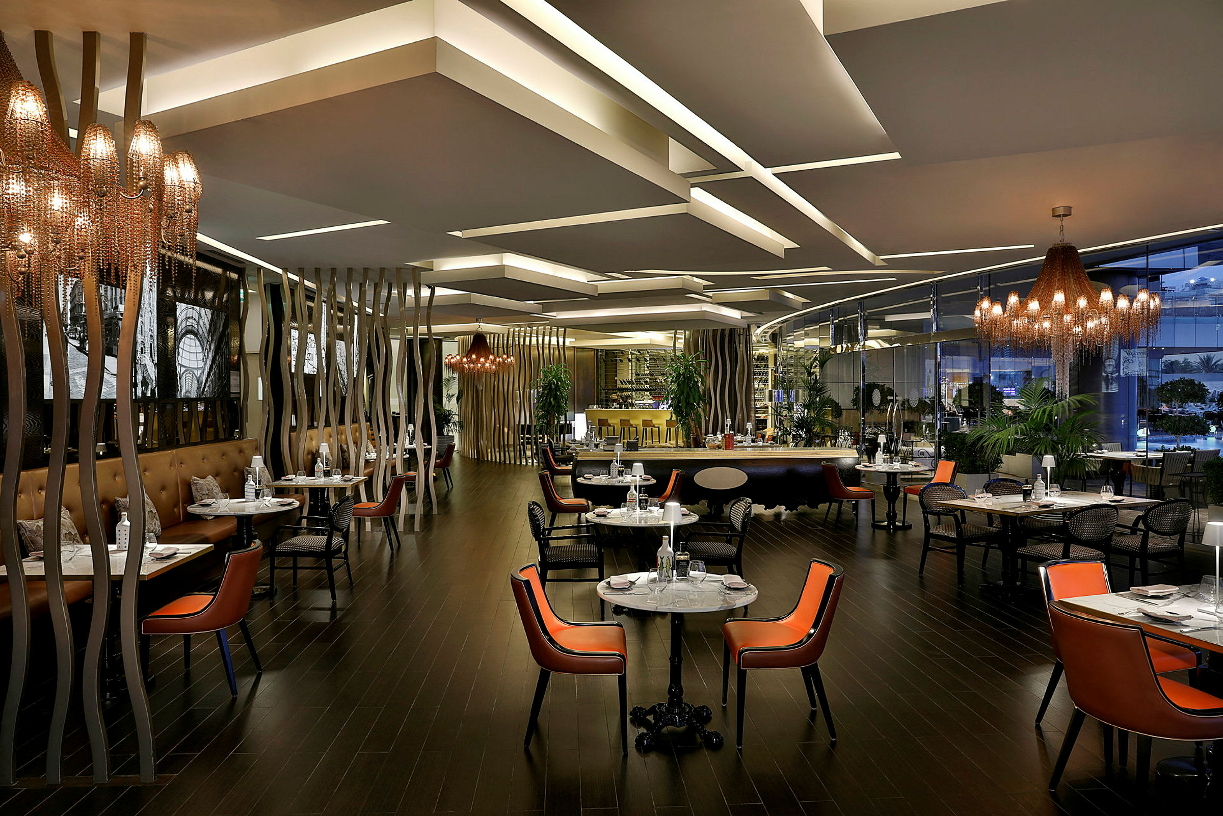 Interiør af en moderne restaurant med belysning, borde og stole. (AI-genereret tekst)