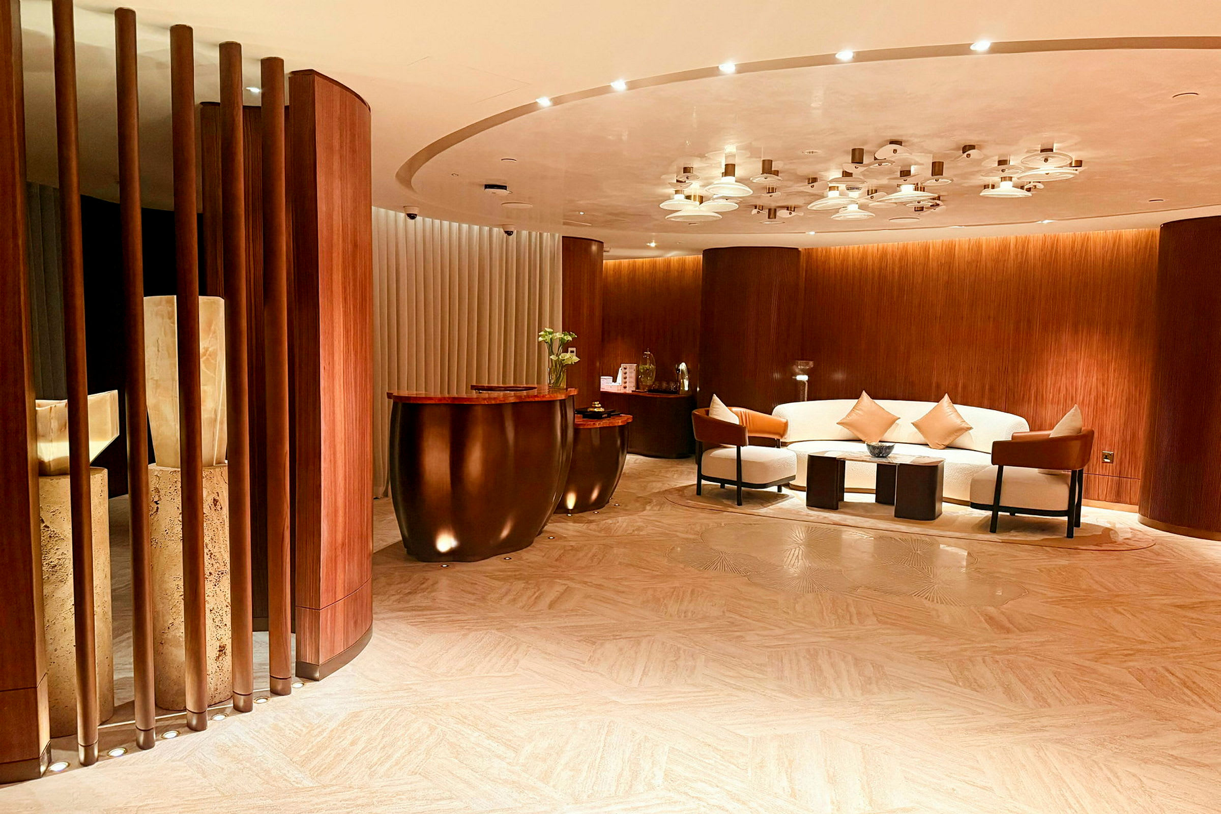 Et stilfuldt hotel- eller kontorområde med sofagruppe, sofabord og marmordetaljer, omgivet af træpanelvægge. (AI-genereret tekst)