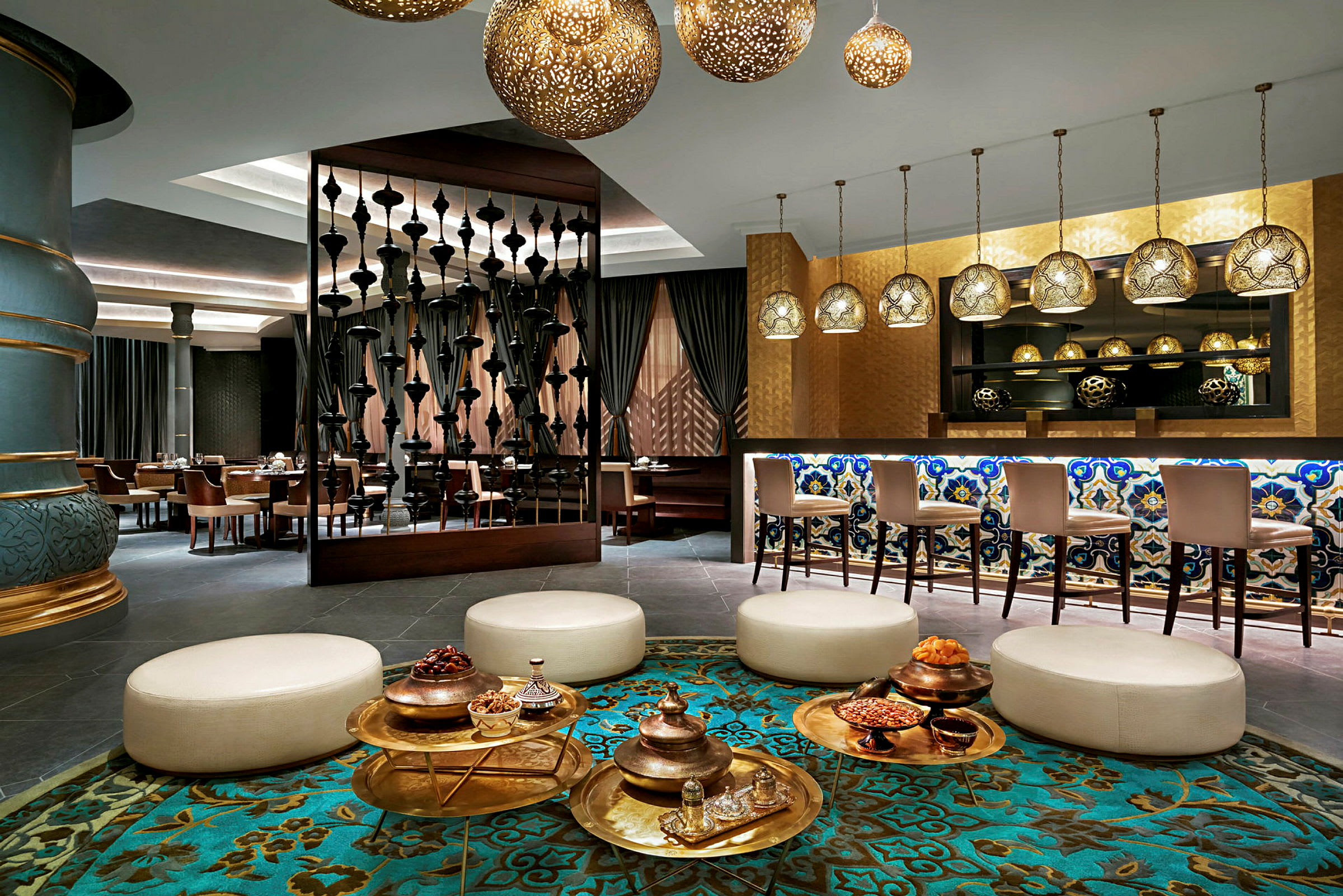 En elegant hotellobby med siddegrupper, dekorative lamper og en bar med mosaikdetaljer. (AI-genereret tekst)