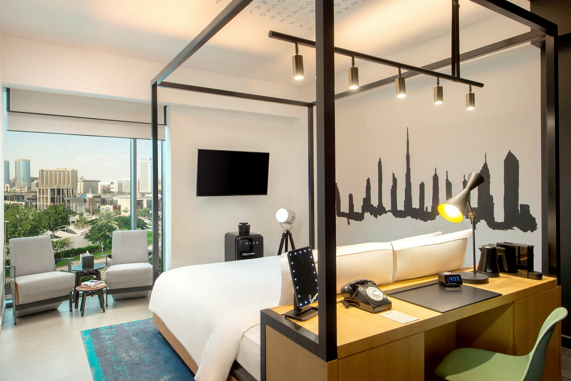 Et moderne hotelværelse med en dobbeltseng, skrivebord og panoramaudsigt over en by. (AI-genereret tekst)
