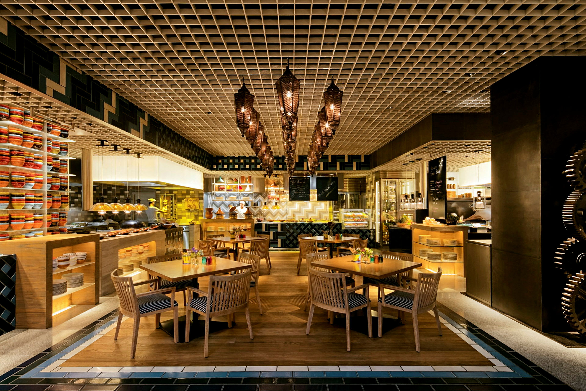Restaurant med træborde og stole, samt dekorativ belysning og hylder med farverige genstande. (AI-genereret tekst)