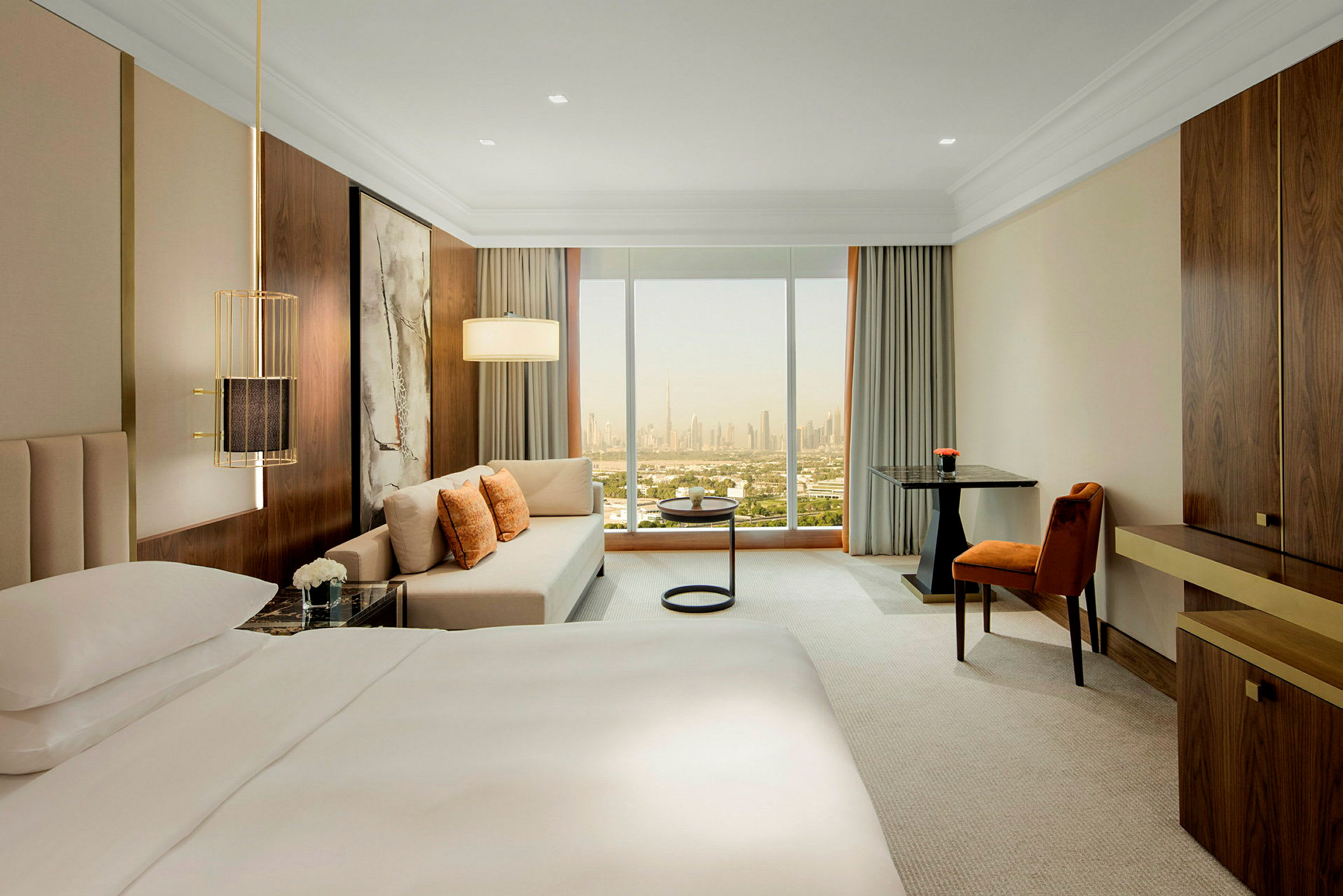 Moderne hotelværelse med stor seng, sofahjørne og vindue med udsigt over byens skyline. (AI-genereret tekst)