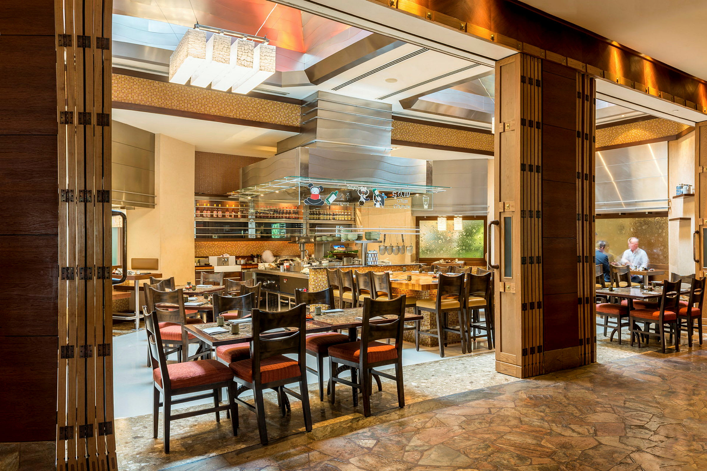 Restaurant med åbent køkken og siddepladser. (AI-genereret tekst)