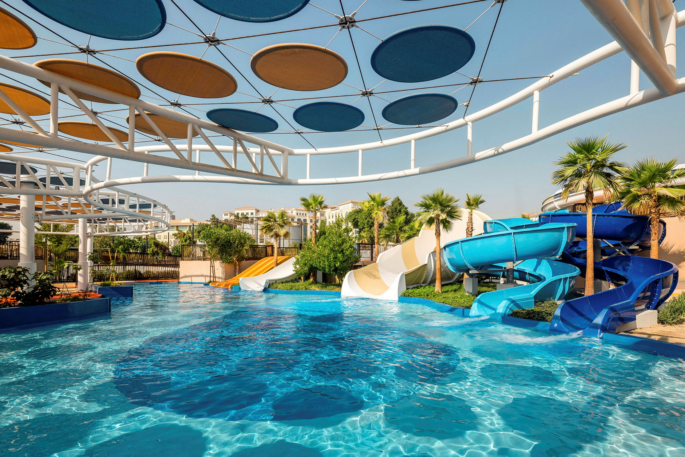 Vandpark med forskellige vandrutsjebaner og en pool under blå himmel. (AI-genereret tekst)