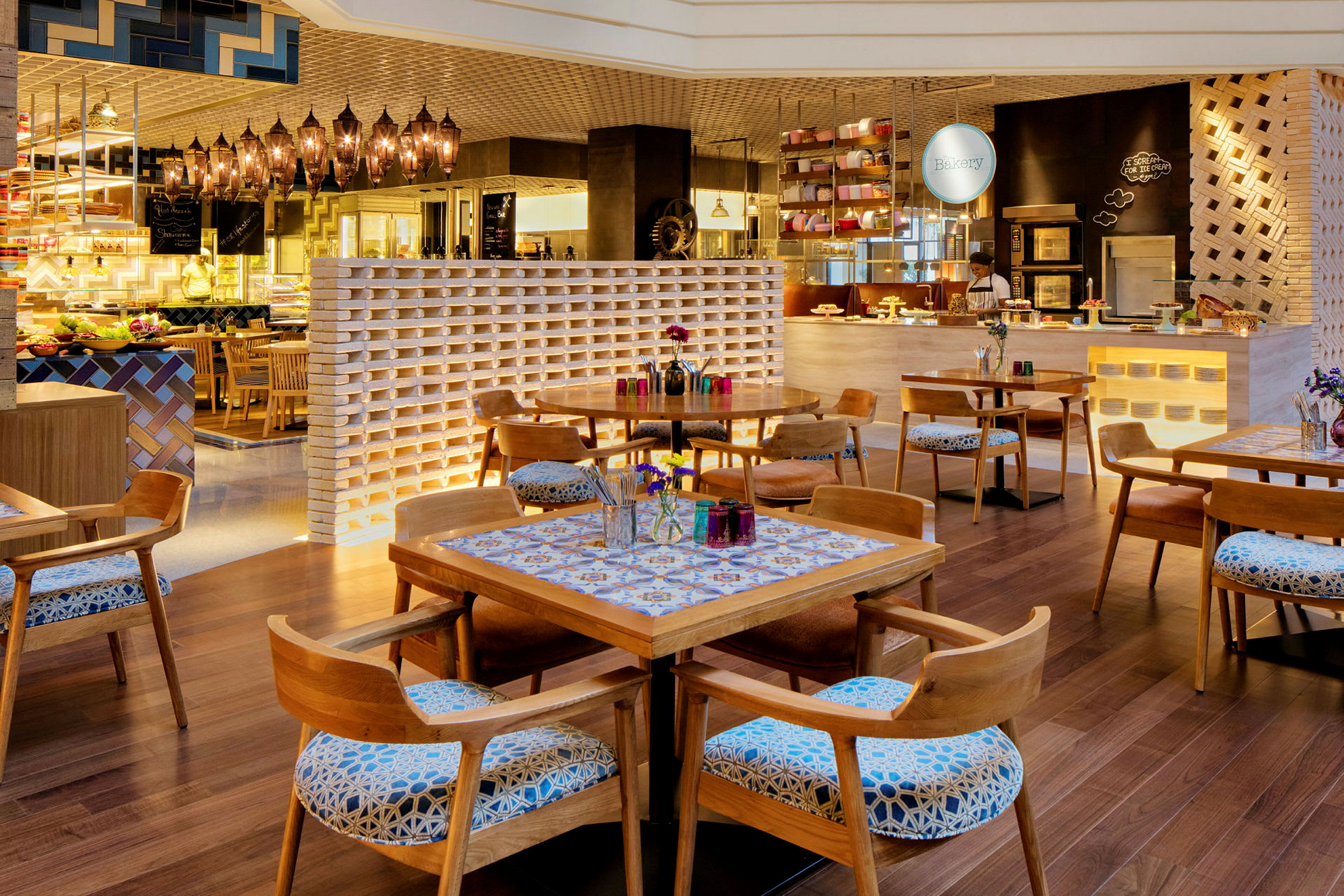 Interiøret i en charmerende restaurant med træborde og stole, dekoreret med blomster og farverige detaljer. (AI-genereret tekst)
