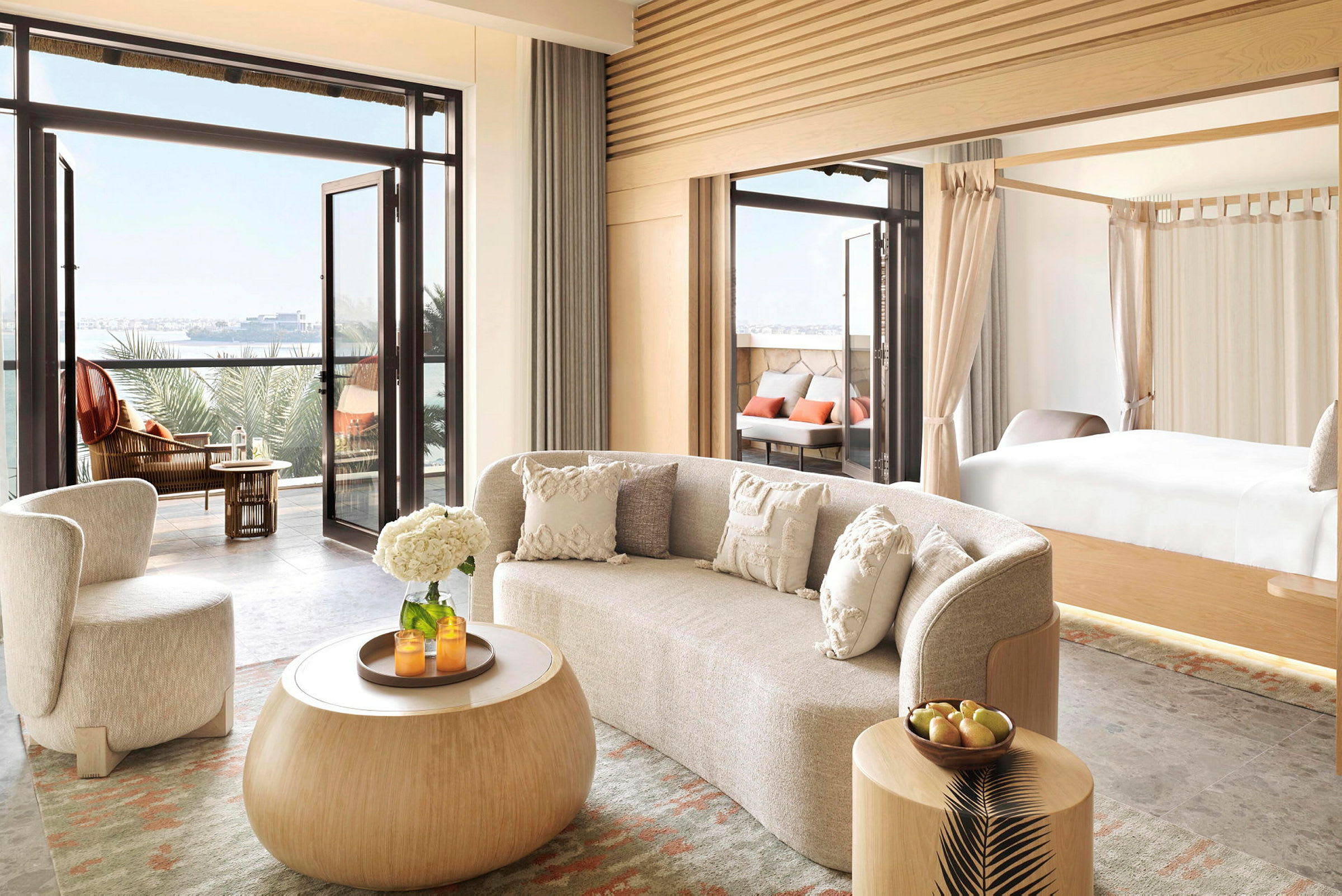 Moderne indrettet hotelsuite med adgang til altan og udsigt over havet. (AI-genereret tekst)