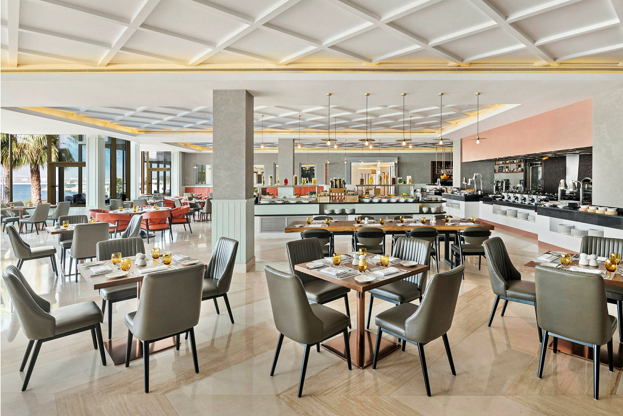 En rummelig og lys restaurant med elegant indretning, dækkede borde og store vinduer, der lader naturligt lys strømme ind. (AI-genereret tekst)