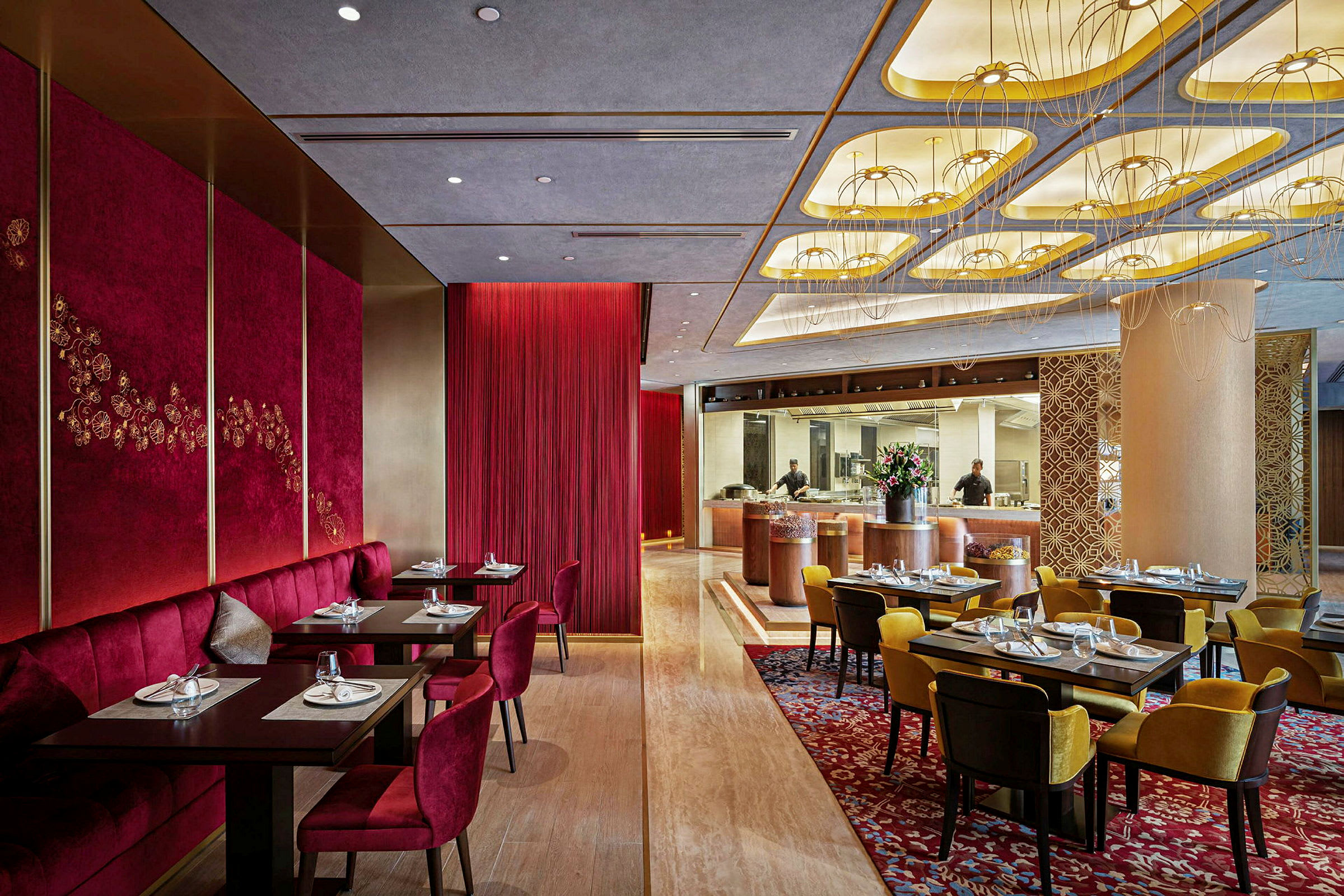 En elegant restaurant med rødt og guld på væggene samt dekorerede borde og stole. (AI-genereret tekst)