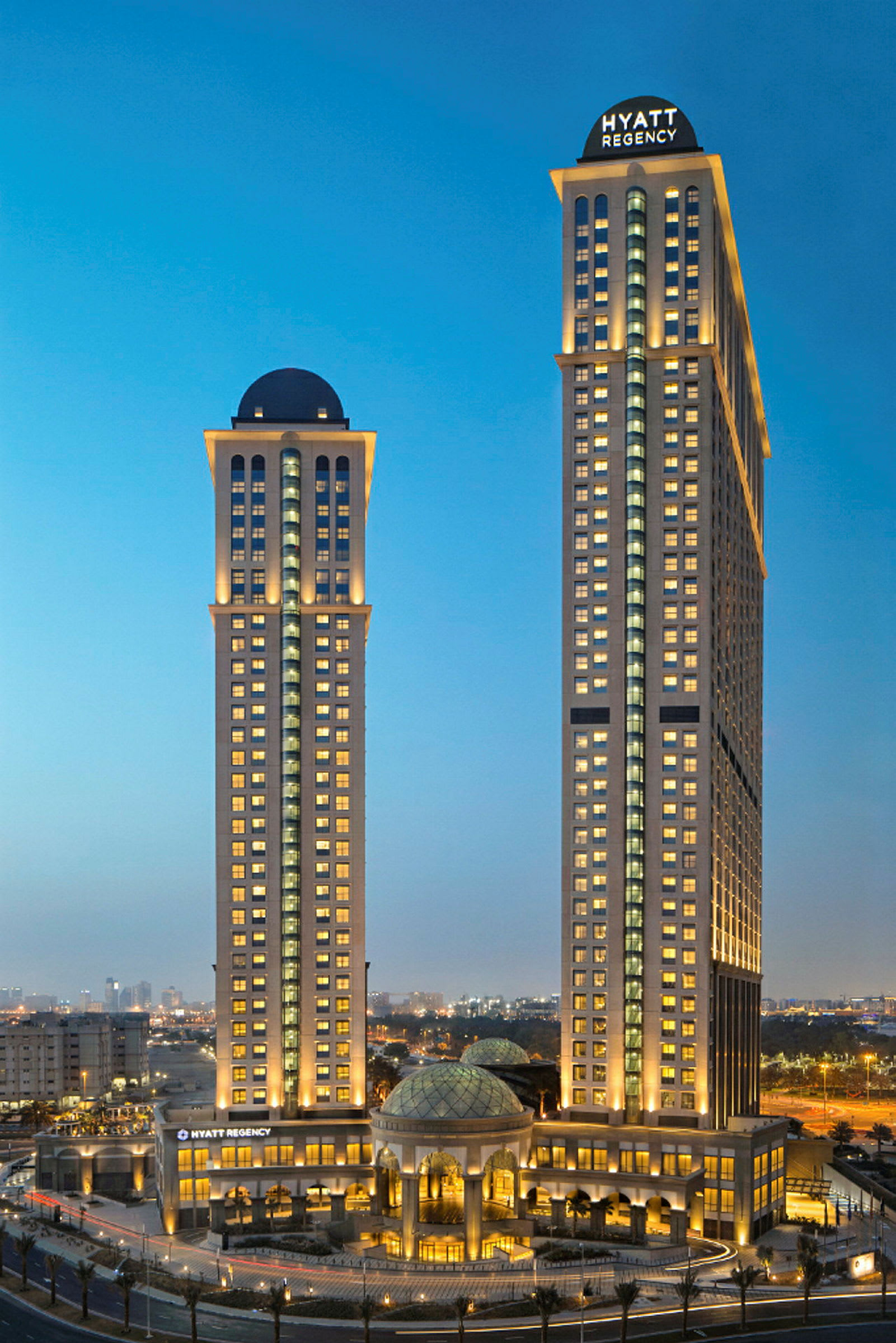 To høje bygninger med belysning, markeret som Hyatt Regency. (AI-genereret tekst)
