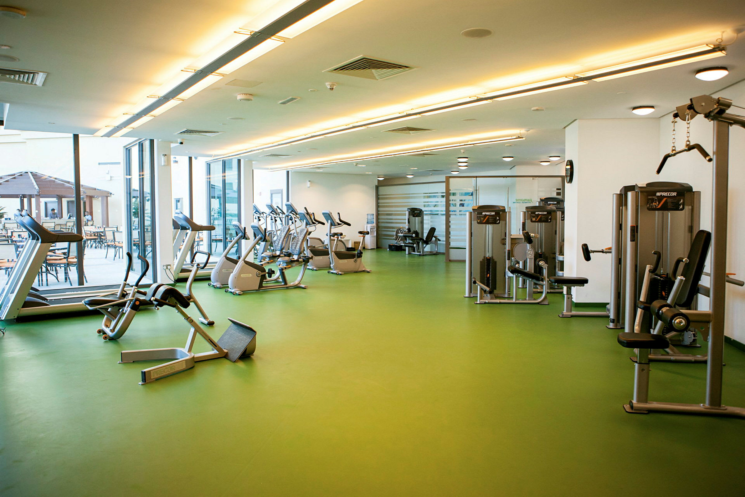 Et fitnesscenter med træningsmaskiner, herunder løbebånd og cykler. (AI-genereret tekst)