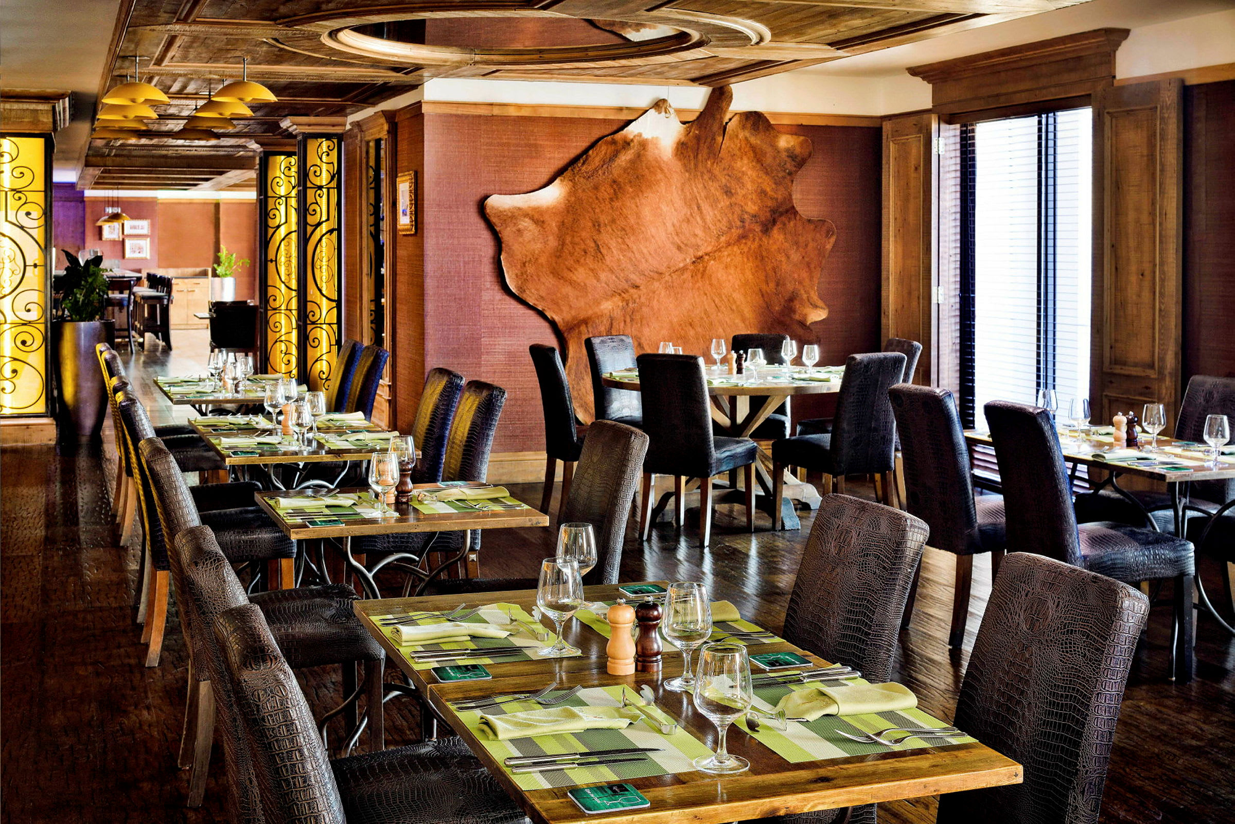 En elegant restaurant med dækkede borde, komfortable stole og smagfuld indretning. (AI-genereret tekst)