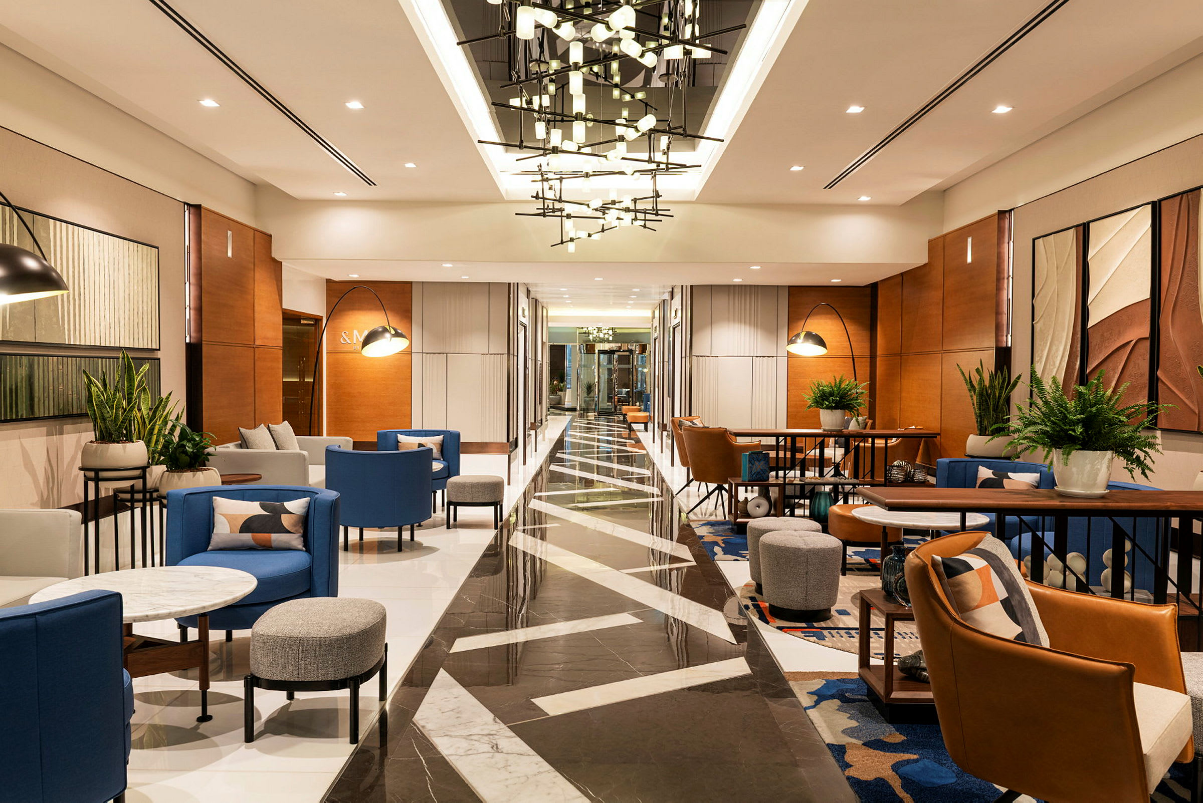 Et moderne hotellobbyområde med siddeområder, borde og belysning. (AI-genereret tekst)