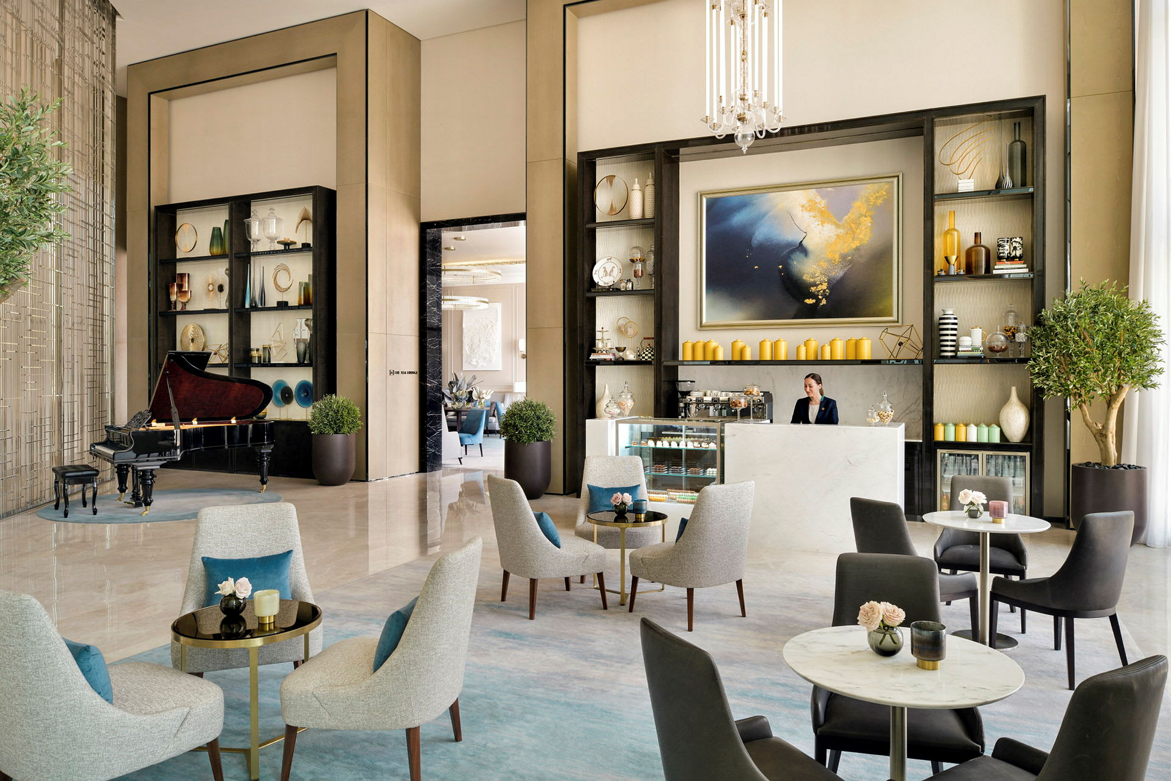 Et elegant loungeområde med siddepladser, et klaver og en reception med hylder dekoreret med vaser og kunstgenstande. (AI-genereret tekst)