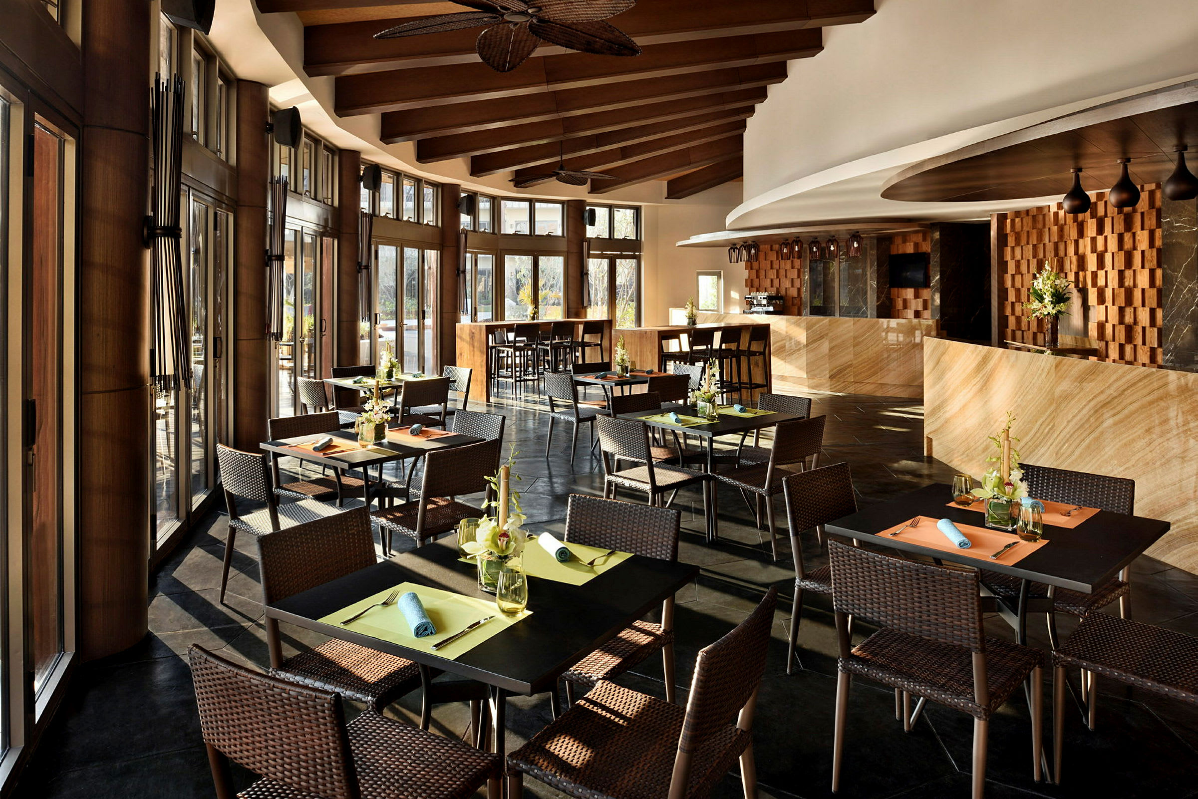 Billede af en elegant restaurant med opdækkede borde og siddepladser. Interiøret har store vinduer og trædetaljer. (AI-genereret tekst)