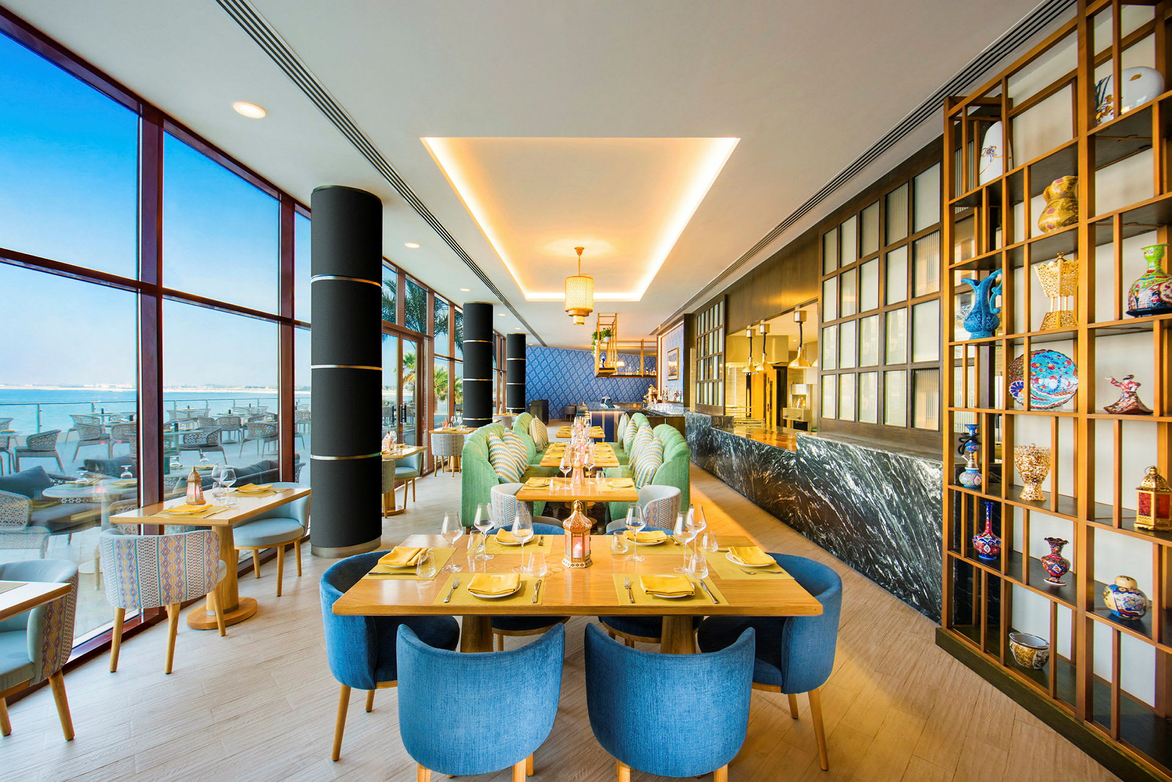 Interiørbillede af en moderne restaurant med farverige stole, dækkede borde og dekorationer. (AI-genereret tekst)