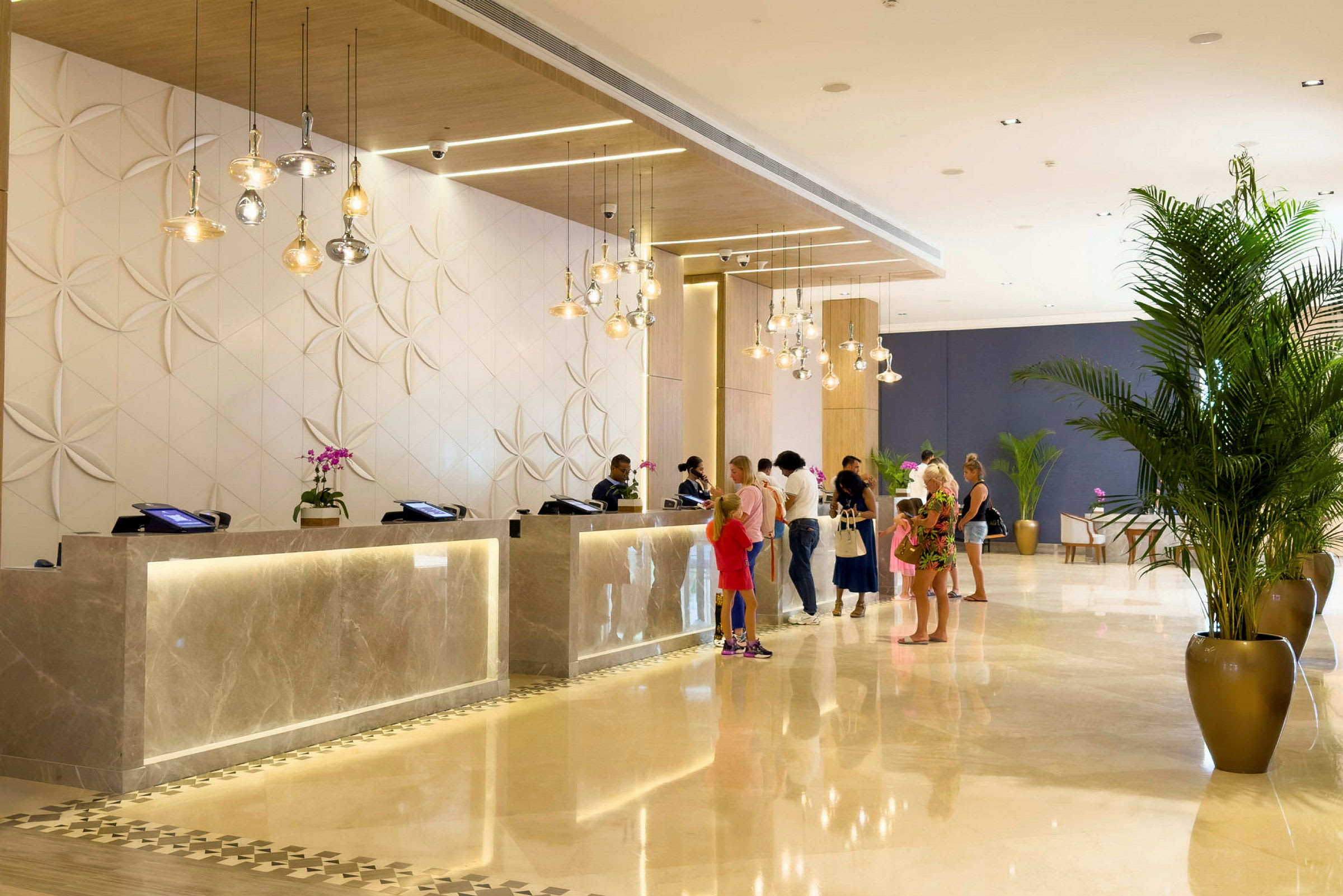 Hotelreception med gæster ved skranken omgivet af moderne og lys indretning. (AI-genereret tekst)