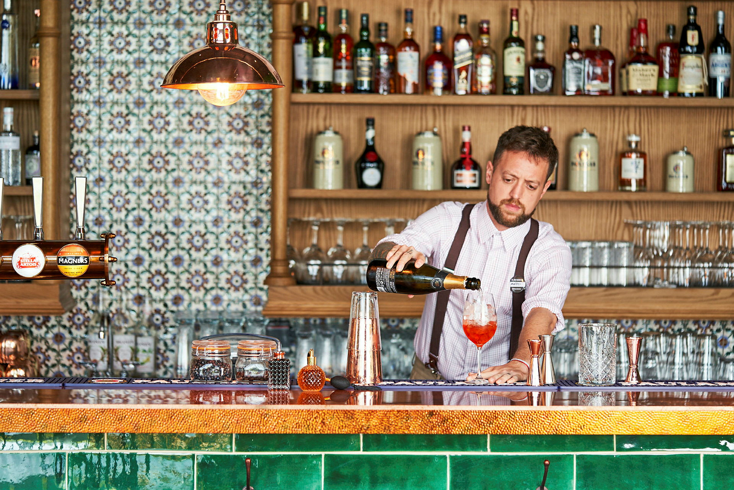 Bartender hælder en drink op ved en bar. (AI-genereret tekst)