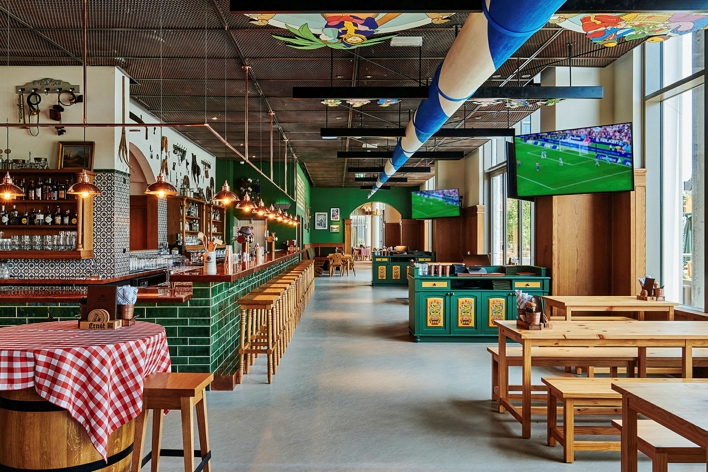 En bar og restaurant med træborde og stole samt tv-skærme, der viser en fodboldkamp. (AI-genereret tekst)