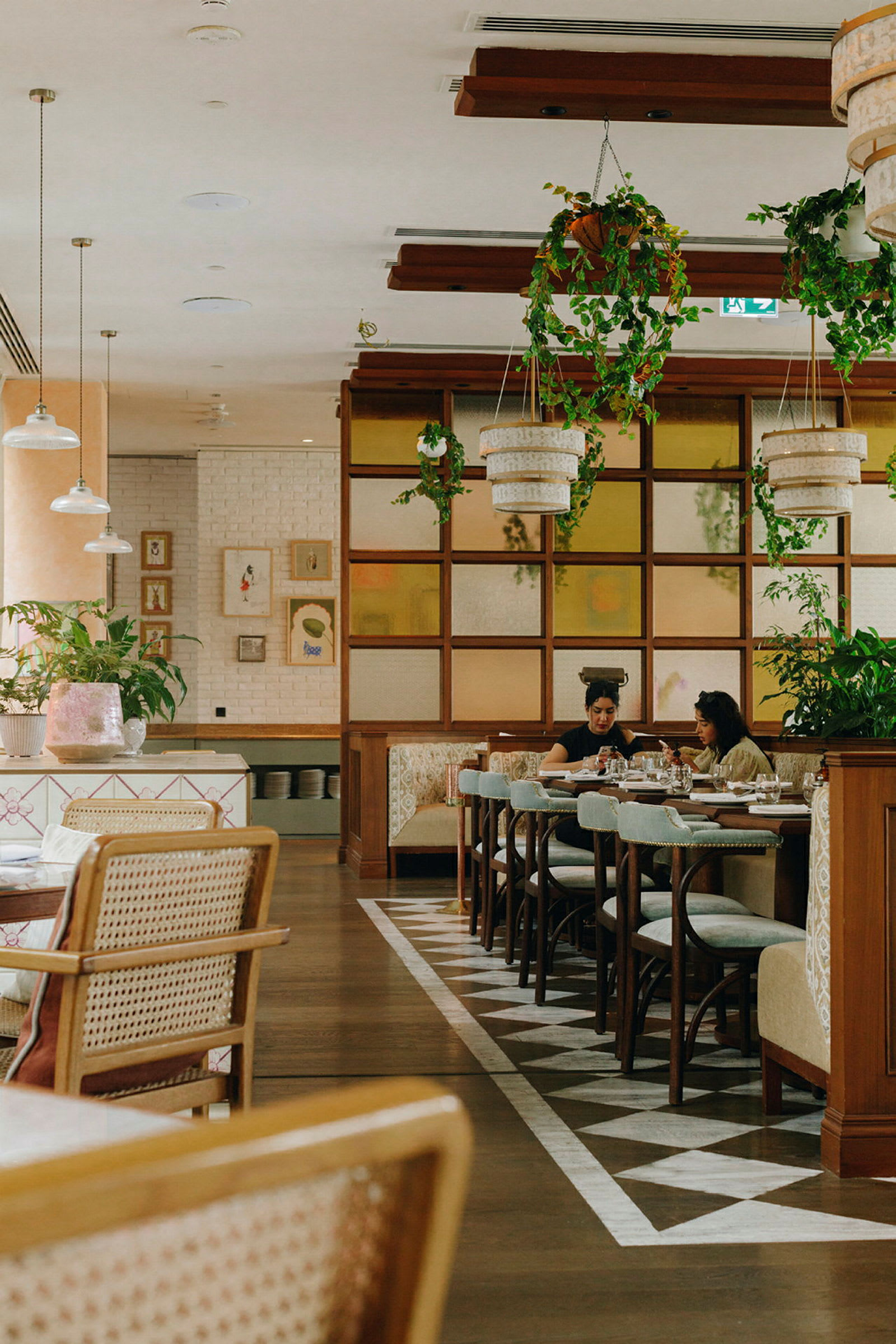 En moderne restaurant med træborde og grønne planter. (AI-genereret tekst)