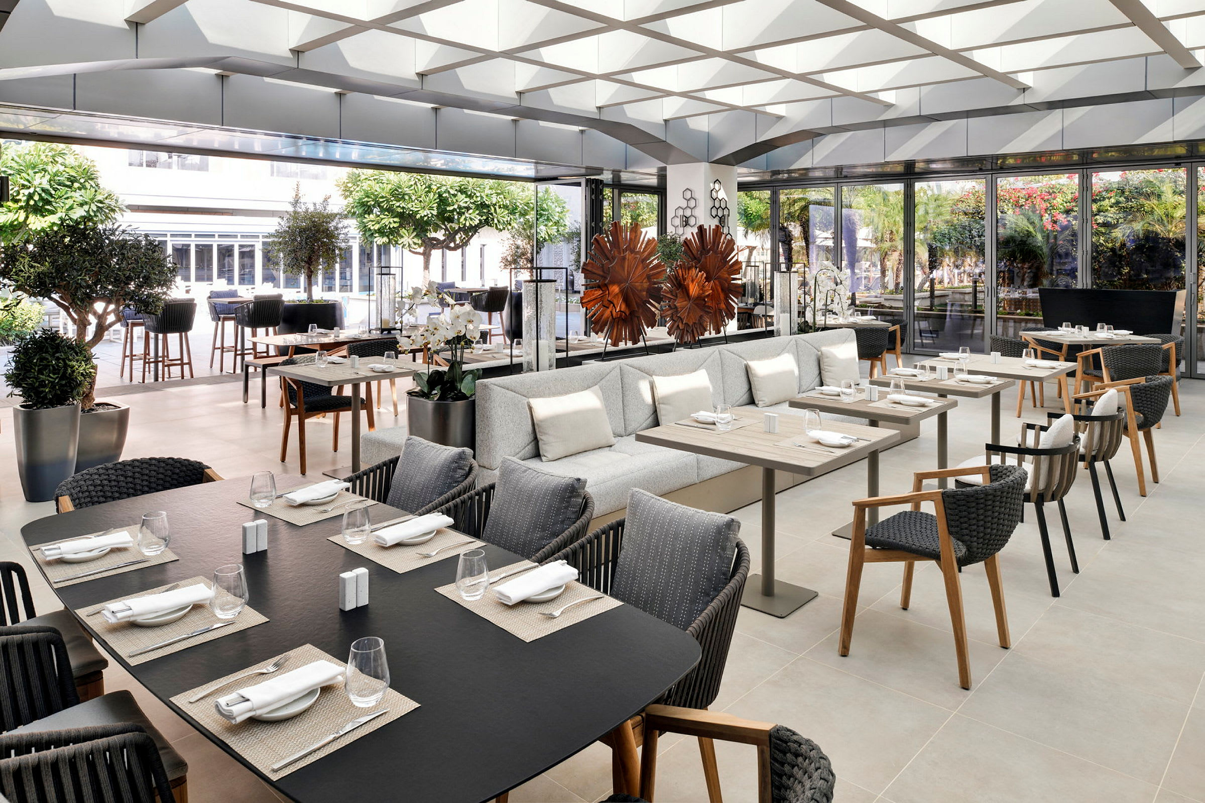 En elegant restaurant med borde og siddepladser, dekoreret med planter og moderne interiør. (AI-genereret tekst)
