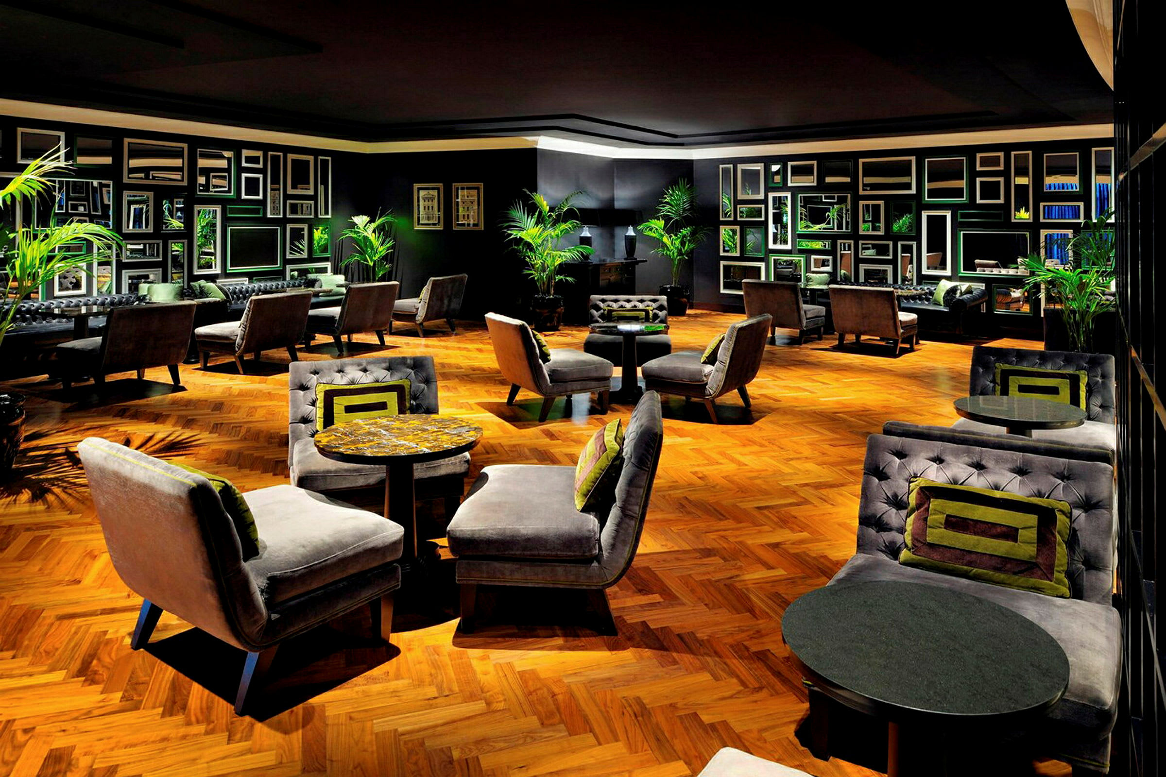 En stilfuld hotellounge med elegante lænestole og sofaer omkring små borde på et trægulv. (AI-genereret tekst)